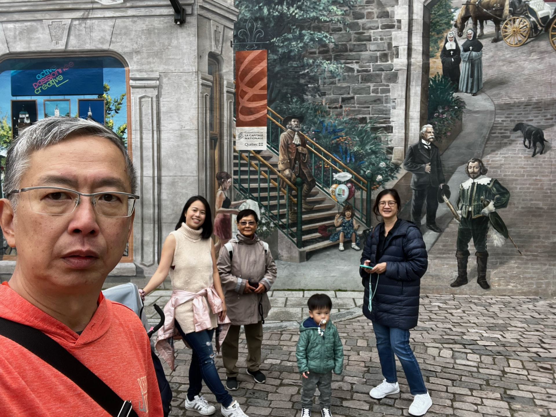 Family posing in front of a colorful historical mural