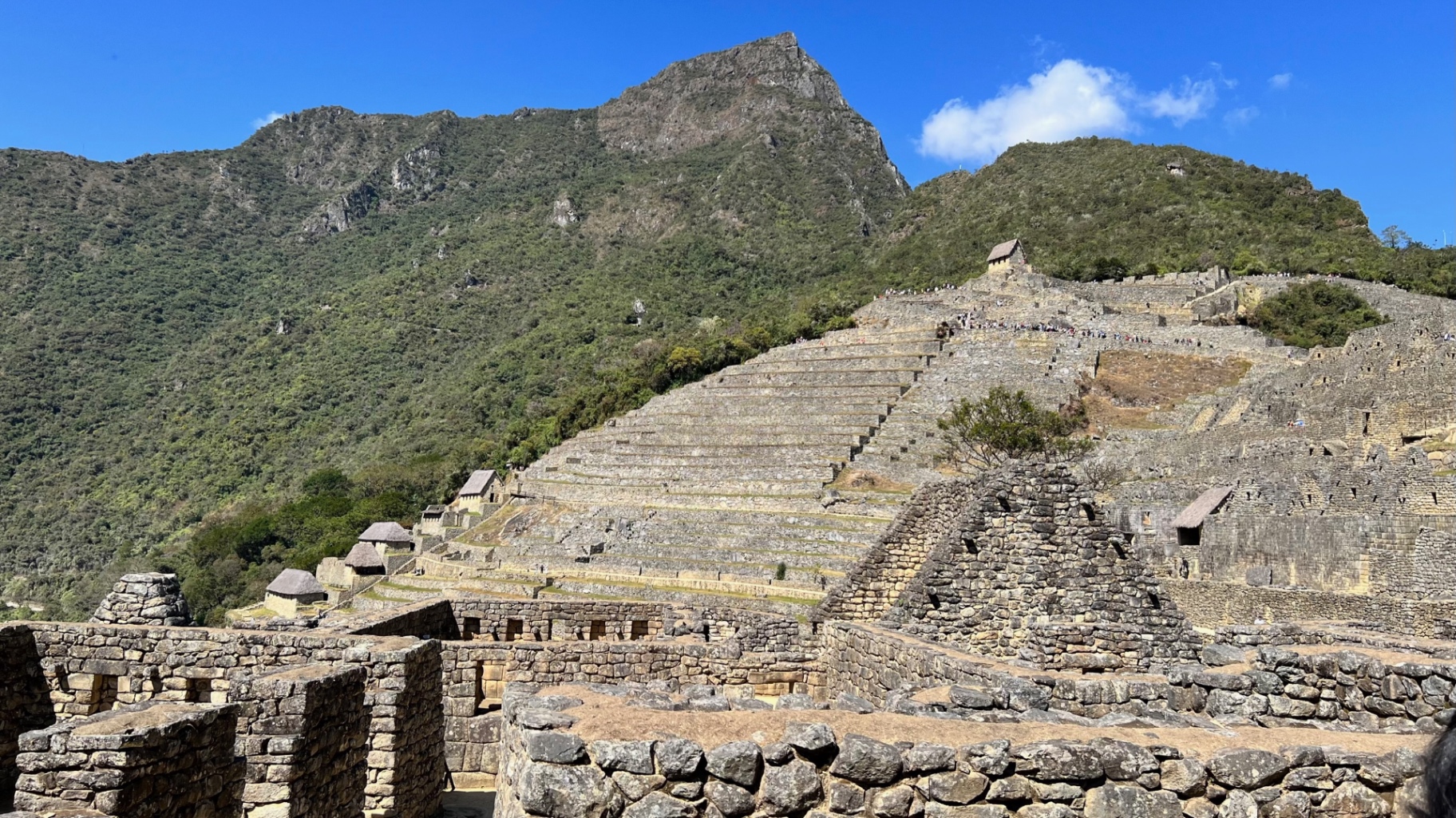 Broad view of agricultural terraces and stone dwellings climbing the hillside