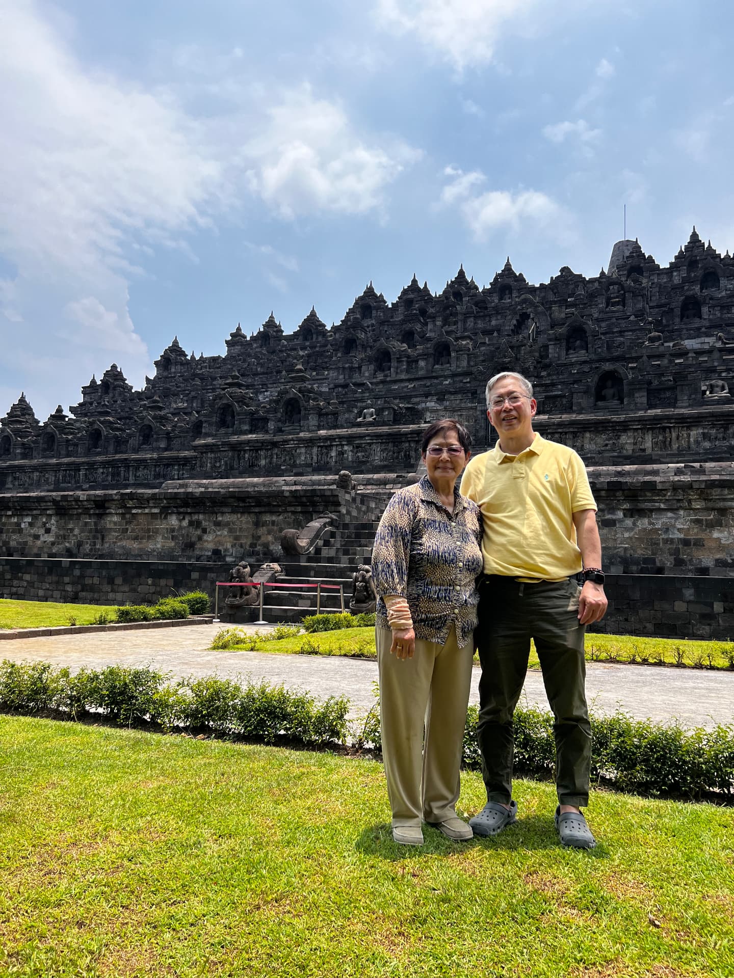 Ken and a family member standing beside the temple