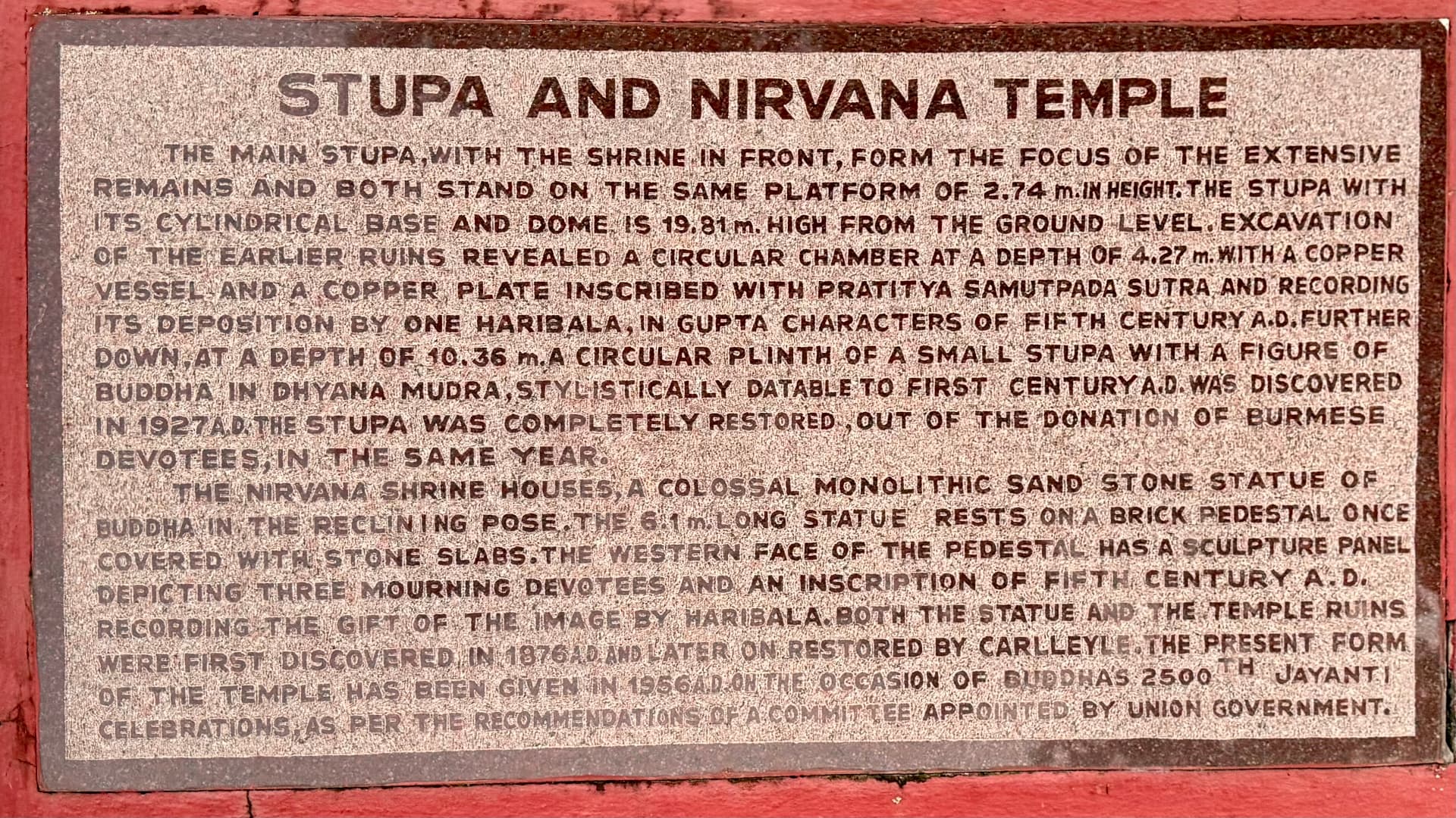 The Stupa and Nirvana Temple plaque explains the site’s history. — Kushinagar, Uttar Pradesh, India.