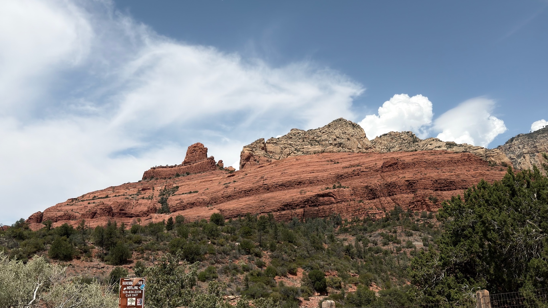 Red sandstone ridge under a blue sky with white clouds