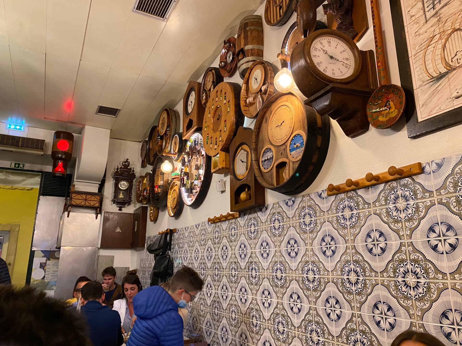 A restaurant interior with walls covered in many clocks