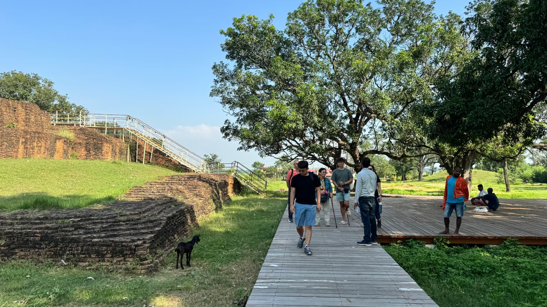 Walking along a raised path through the historic grounds. — Sacred sites near Lumbini, Nepal.