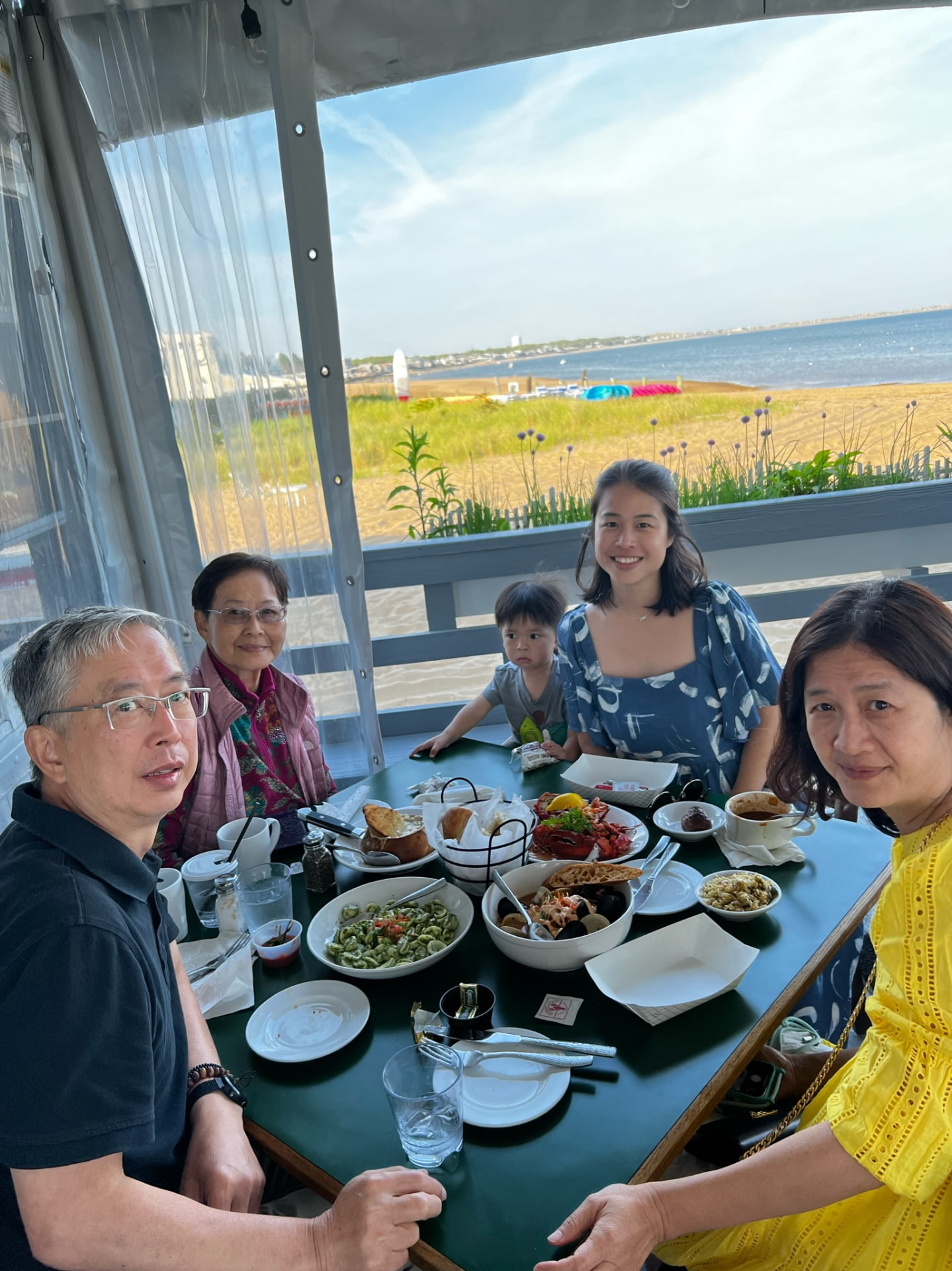 Family gathered around a seafood lunch overlooking the beach