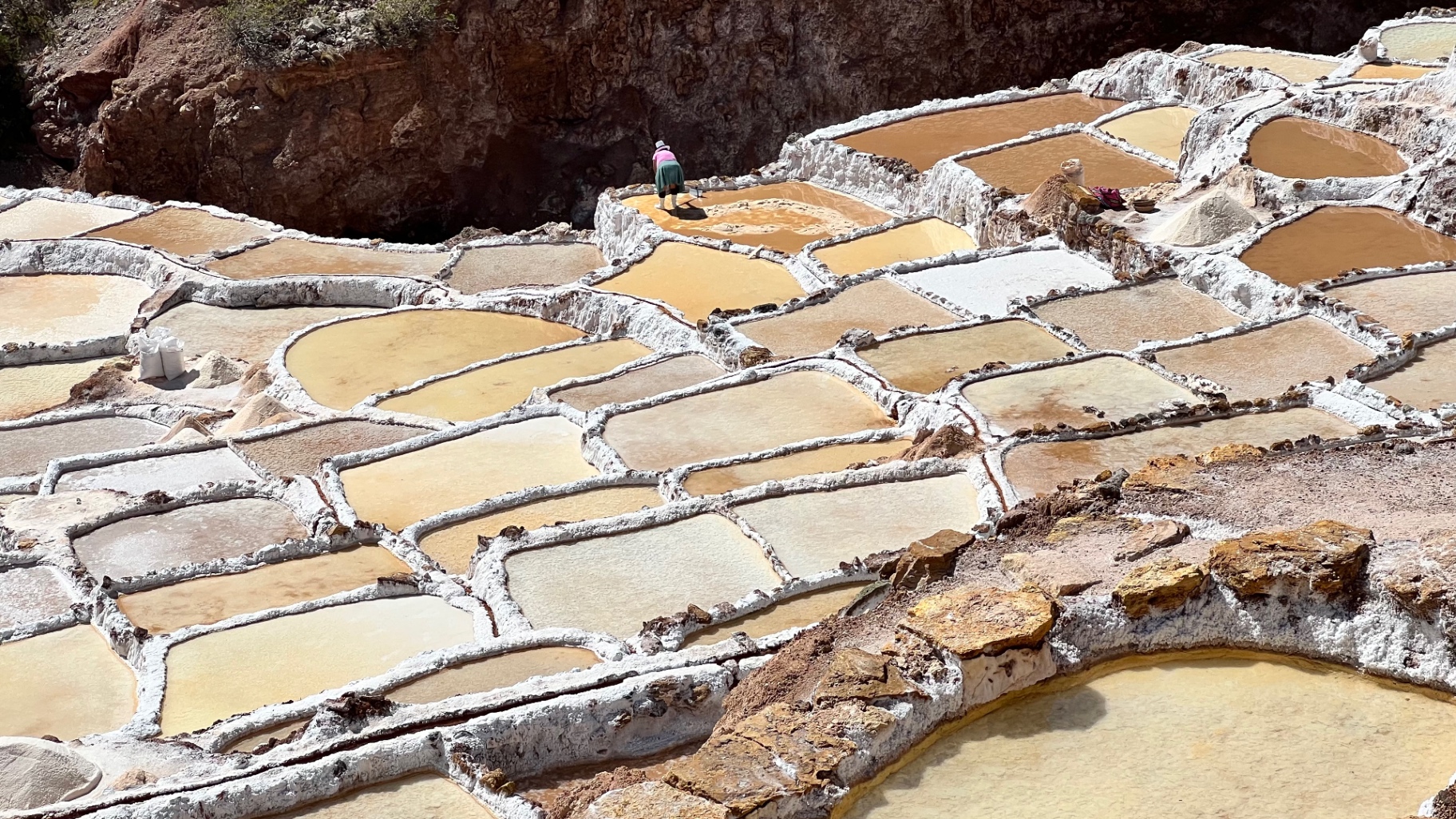 Sunlit ochre and white salt pans at Maras