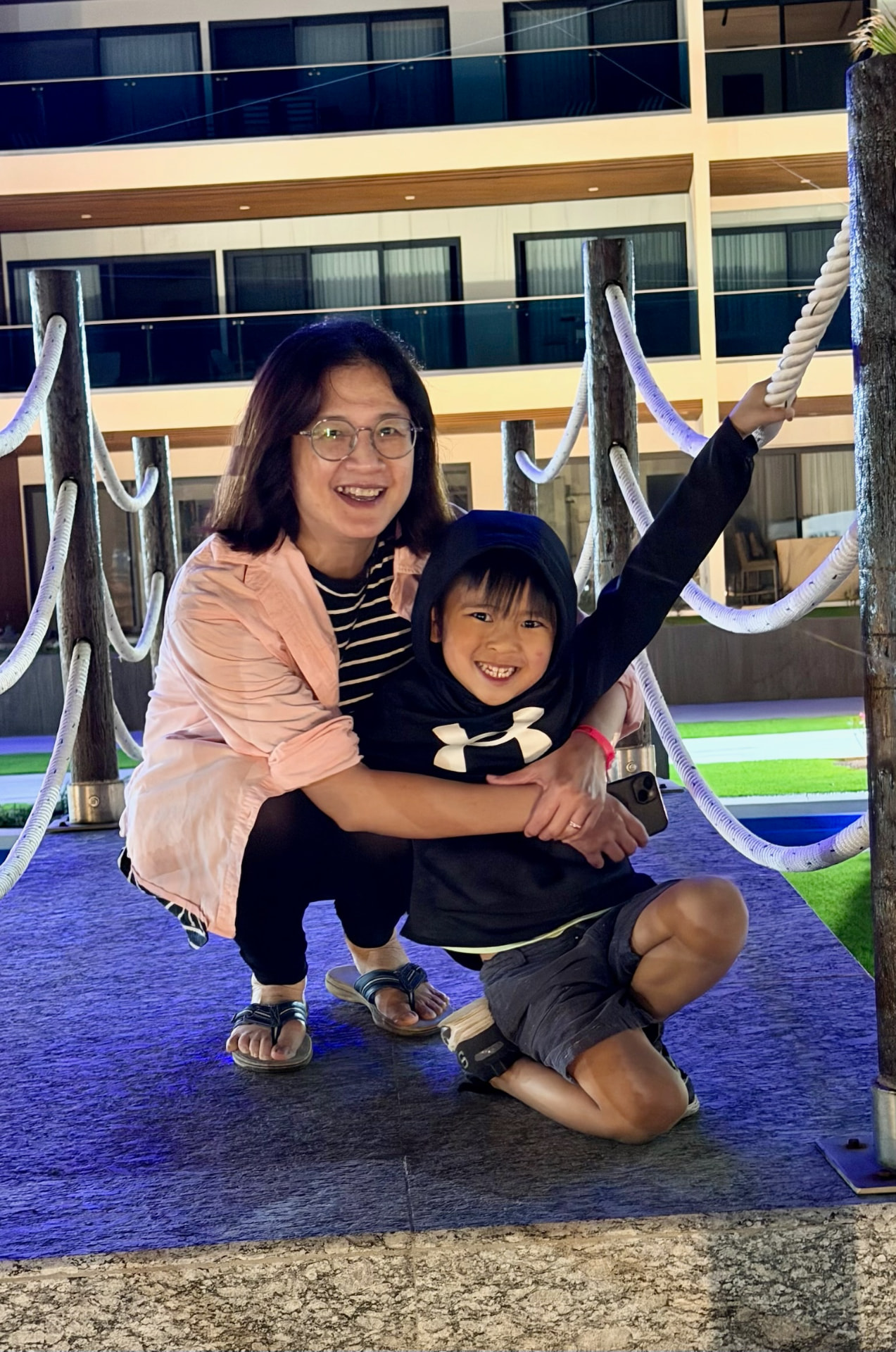 Becky and Kayden smiling together on a rope bridge