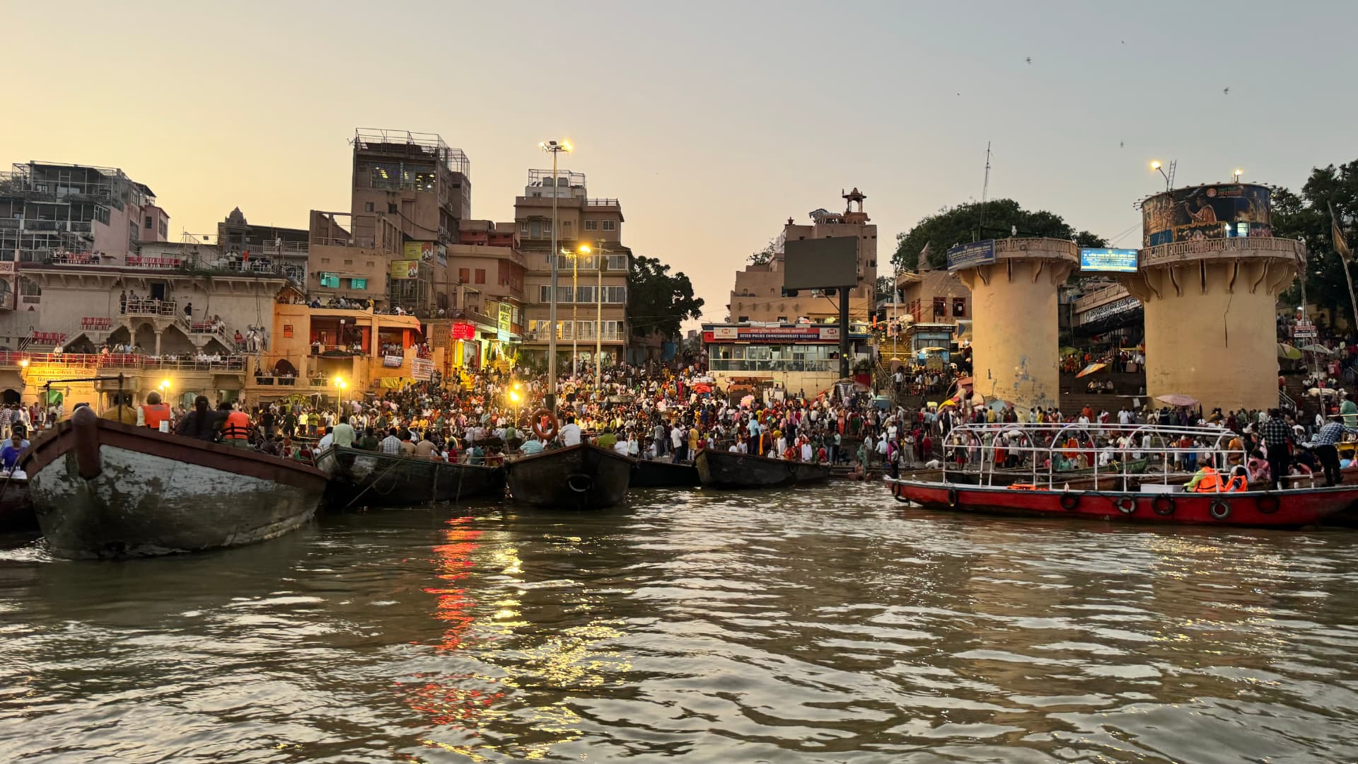 Evening lights begin to glow along the crowded waterfront. — Varanasi, Uttar Pradesh, India.