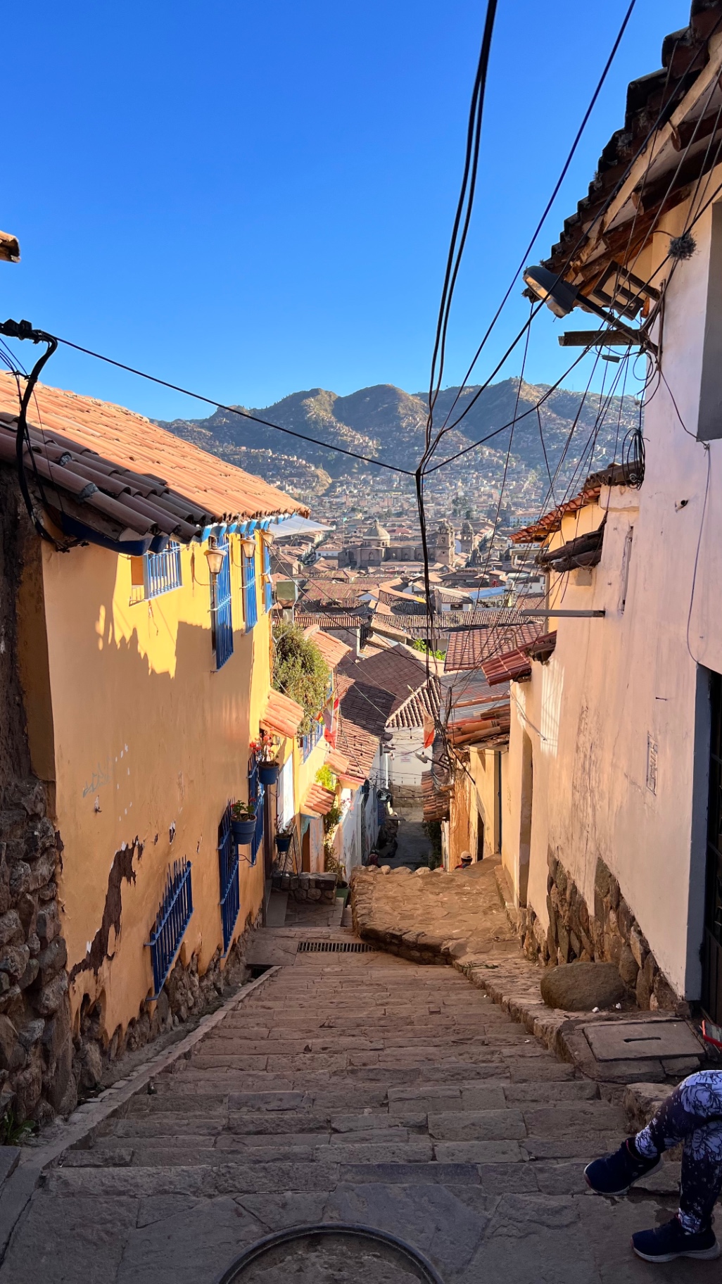 Narrow Cusco street rising toward the surrounding mountains