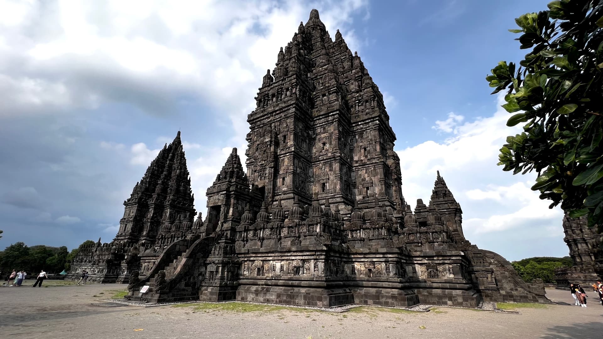 The towering stone temples of Prambanan beneath a blue sky