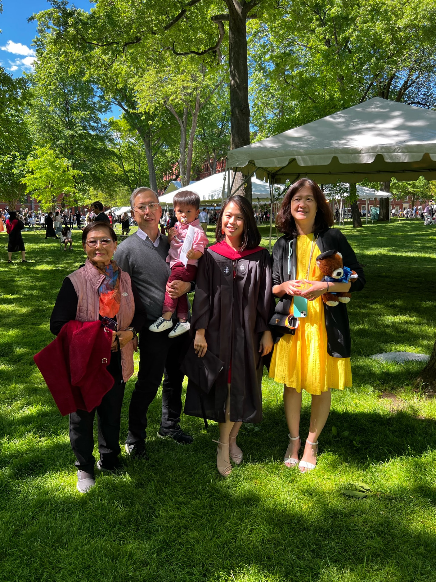 Family portrait on the grass — grandparents, Jocelyn in her gown, and the little one