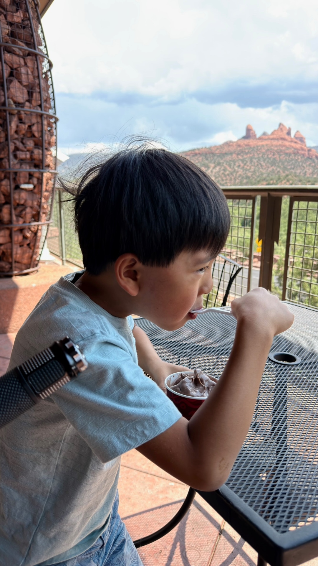 Kayden eating chocolate ice cream at a terrace table