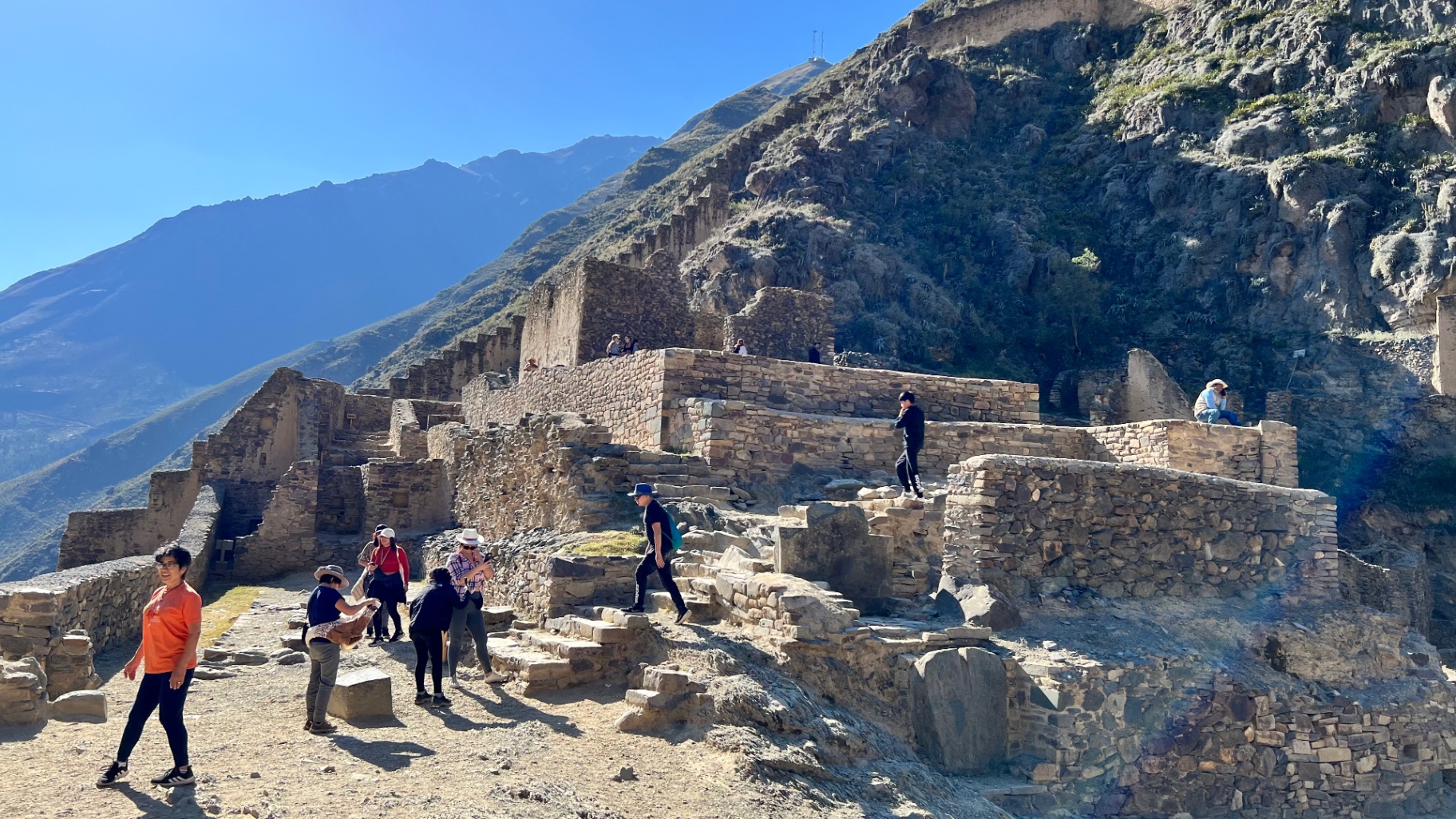 Visitors crossing stone ruins high above the Sacred Valley