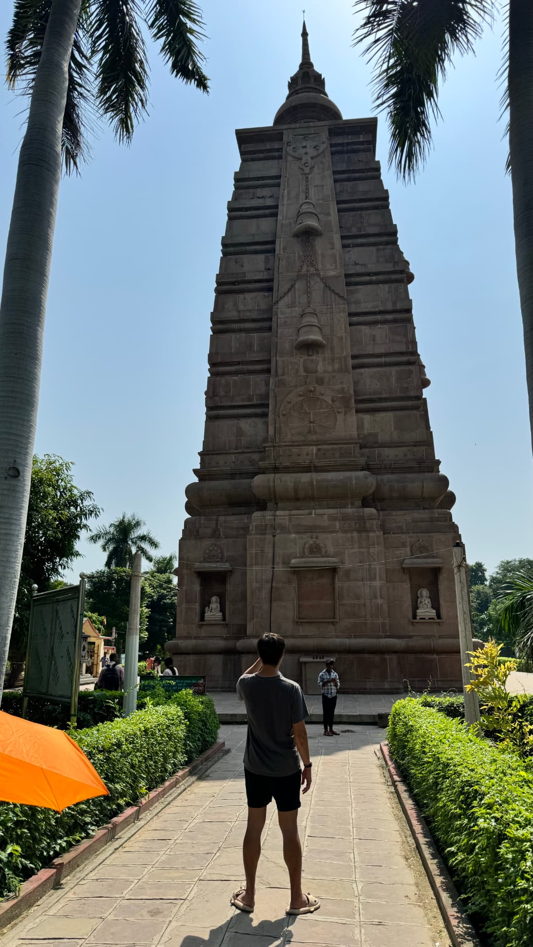 A visitor stands on the path leading to the temple’s tall central tower. — Sarnath, Uttar Pradesh, India.