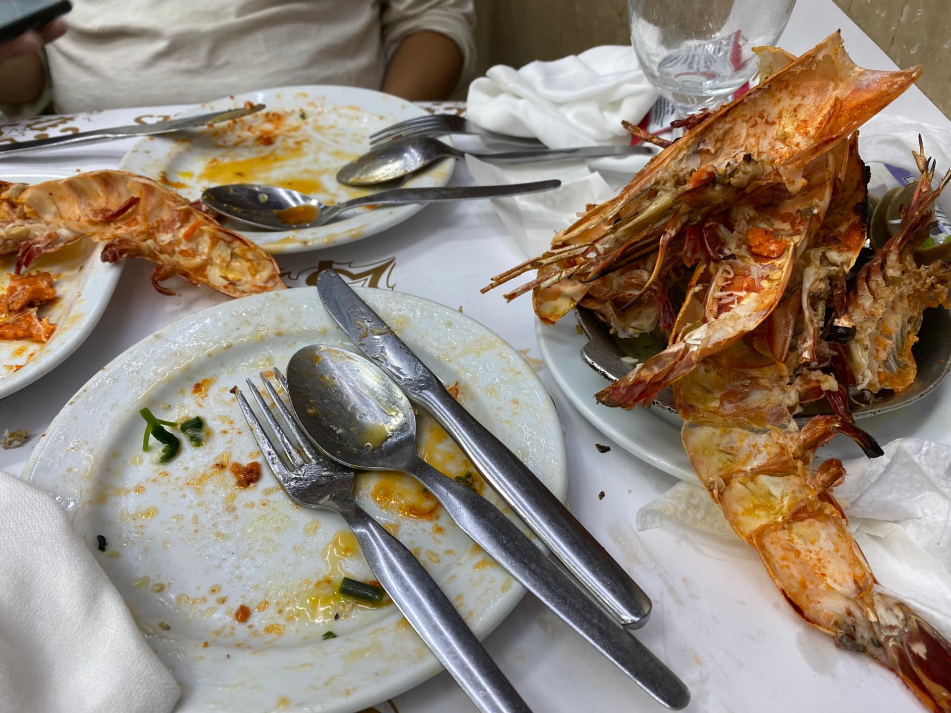 The remains of a seafood meal with shells and silverware