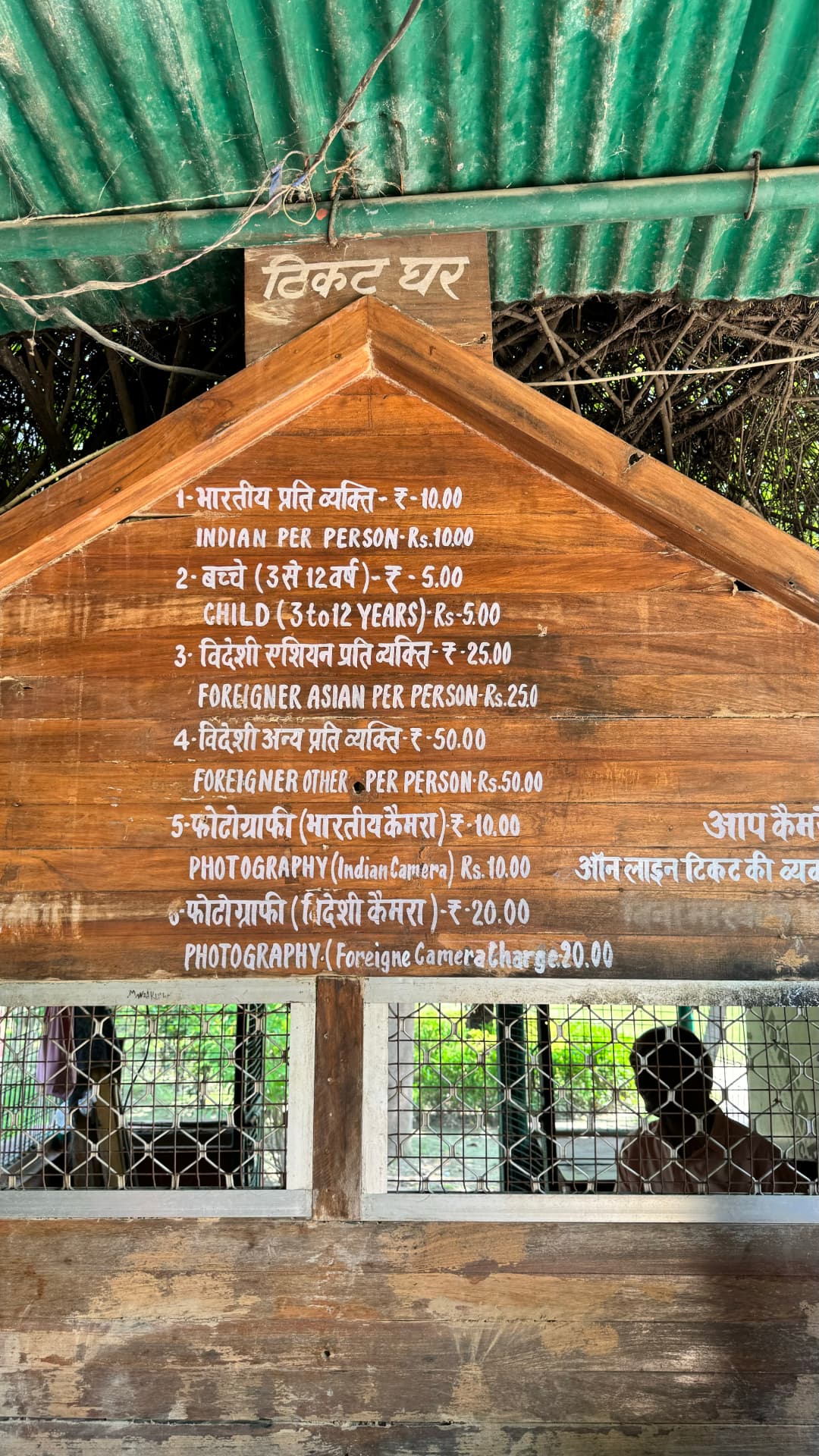 A wooden donation board beneath a corrugated shelter. — Sarnath, Uttar Pradesh, India.