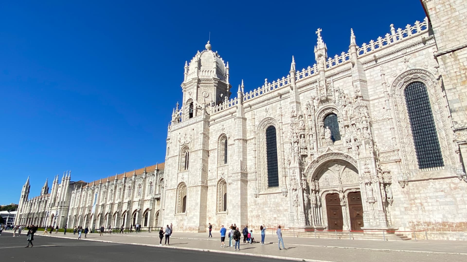 The stone façade of Jerónimos Monastery beneath a clear blue sky