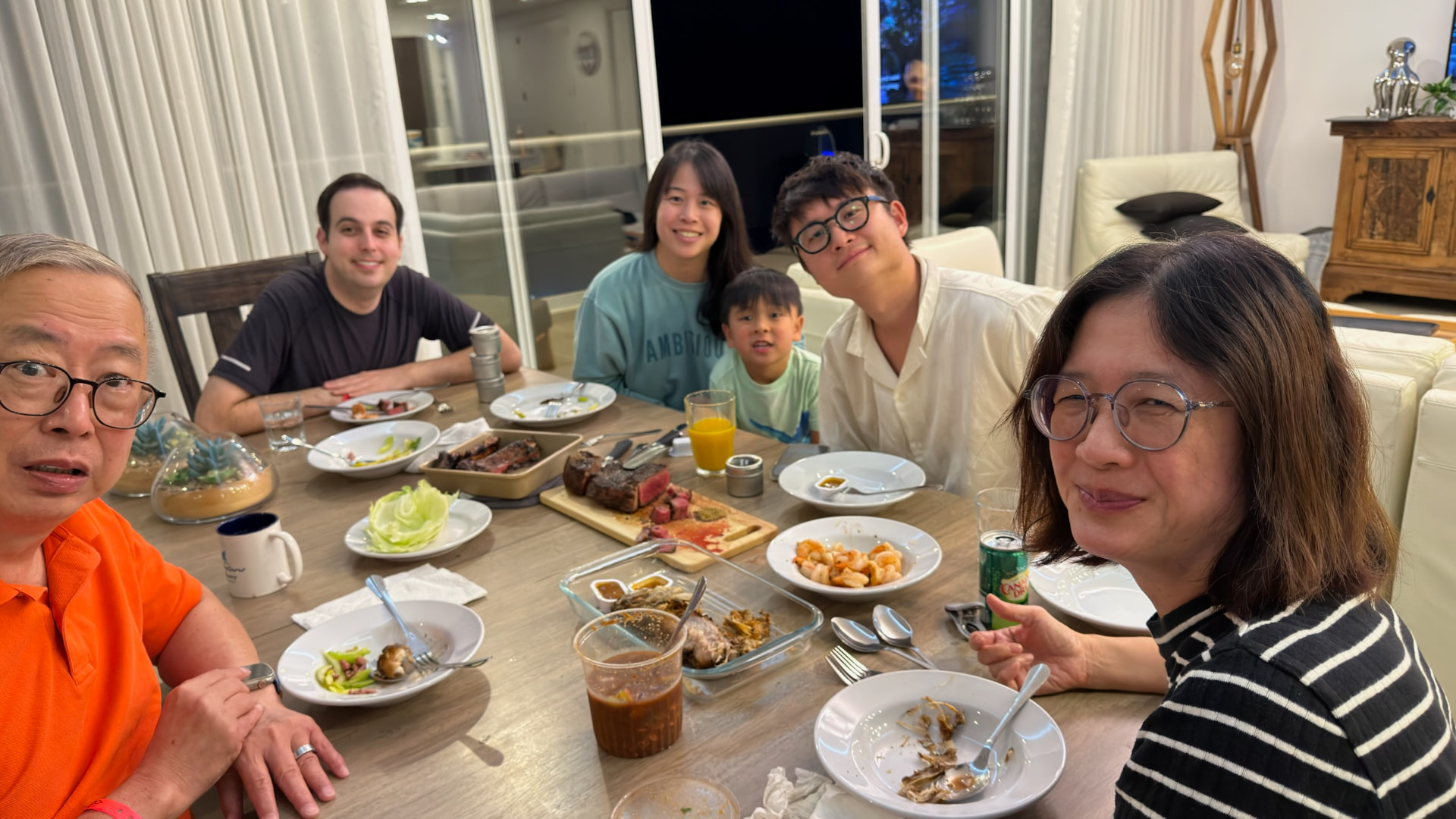 Six family members around a dinner table in their apartment