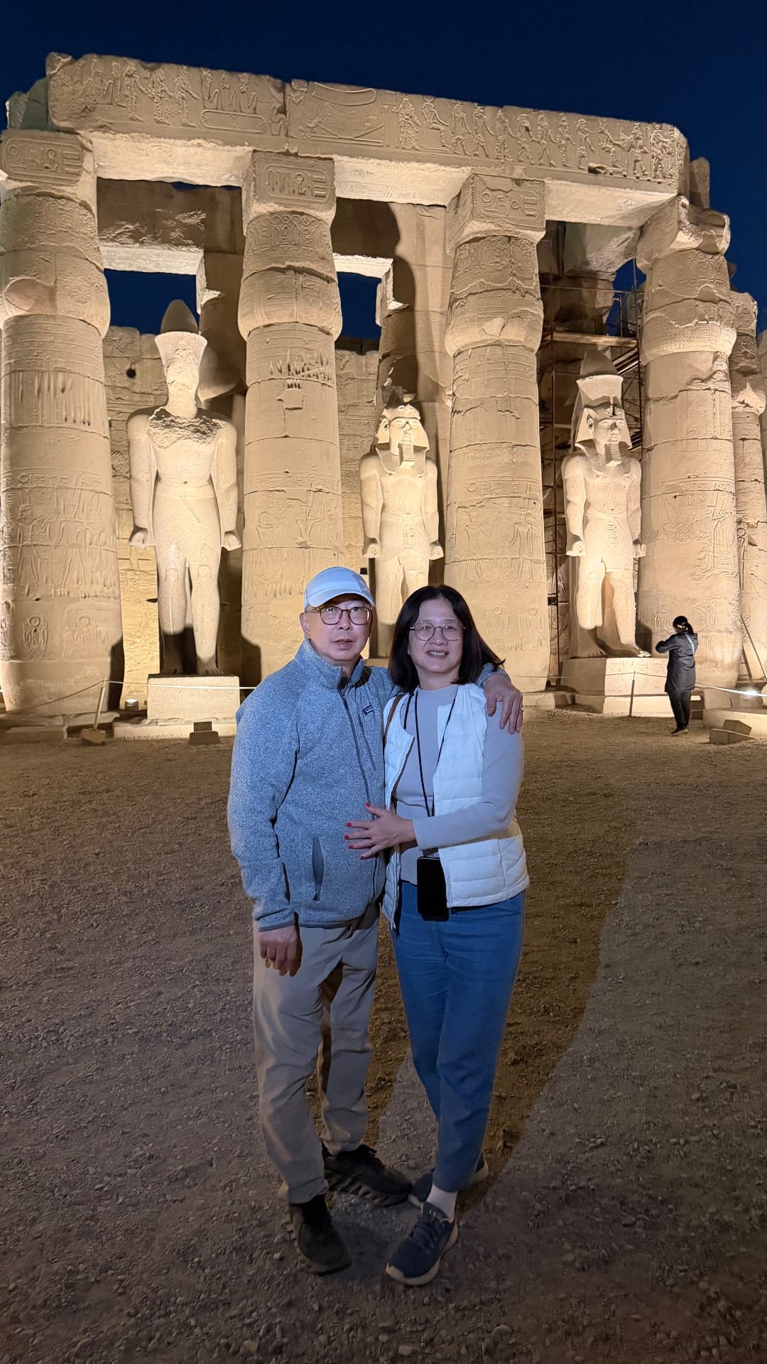 Ken and Becky standing together before the statues and columns of Luxor Temple at night