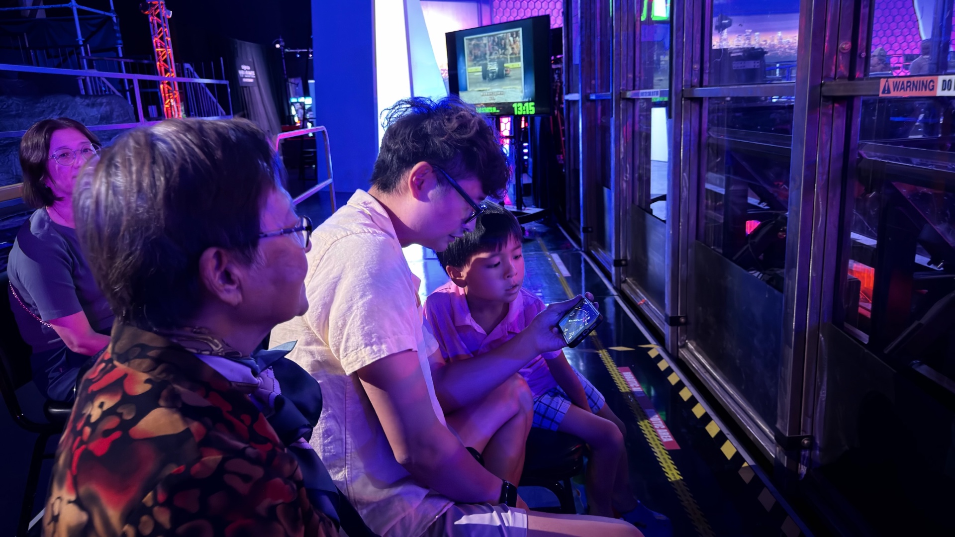 The family watching the arena from ringside seats in blue and pink light