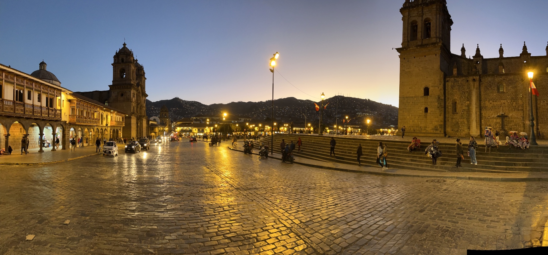 Plaza de Armas reflected in wet paving beneath evening lights