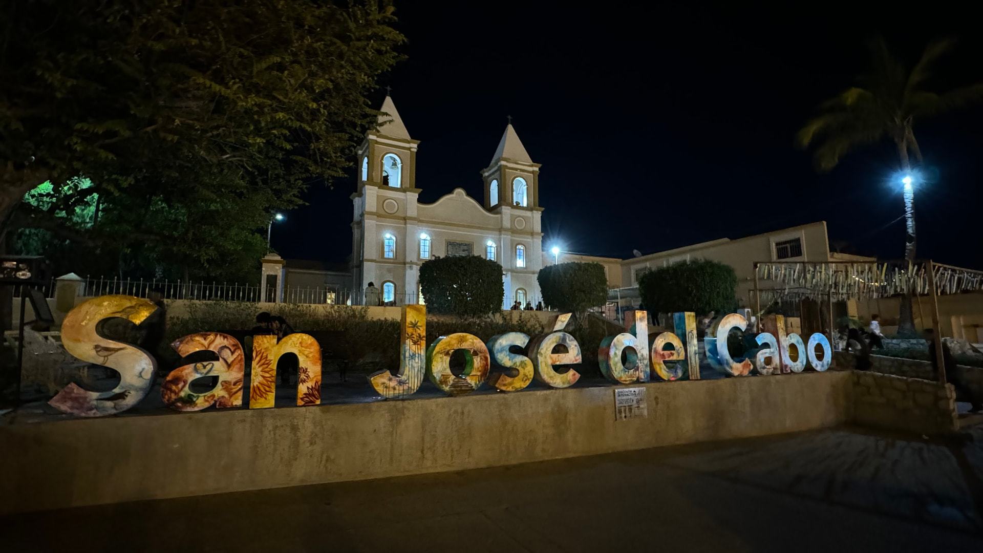 Colorful San José del Cabo letters with the mission church illuminated behind them