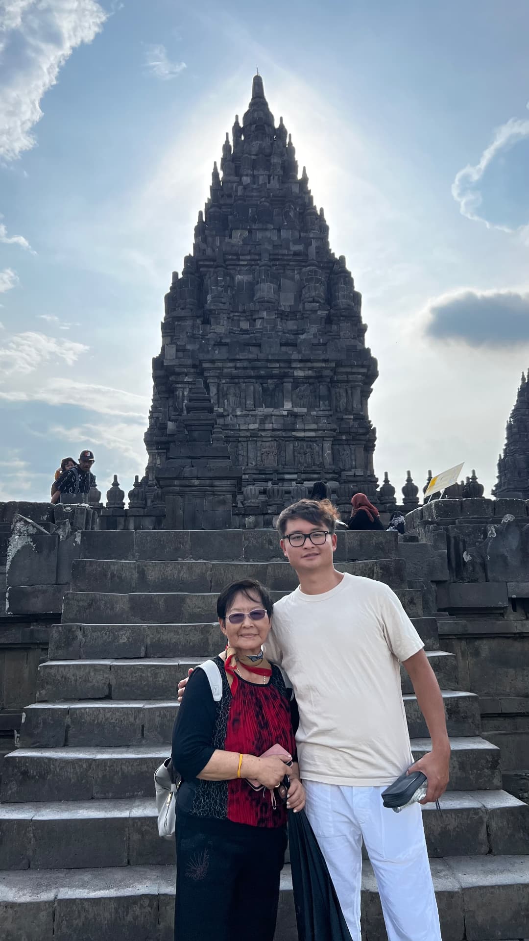 Two travelers posing in front of a Prambanan temple