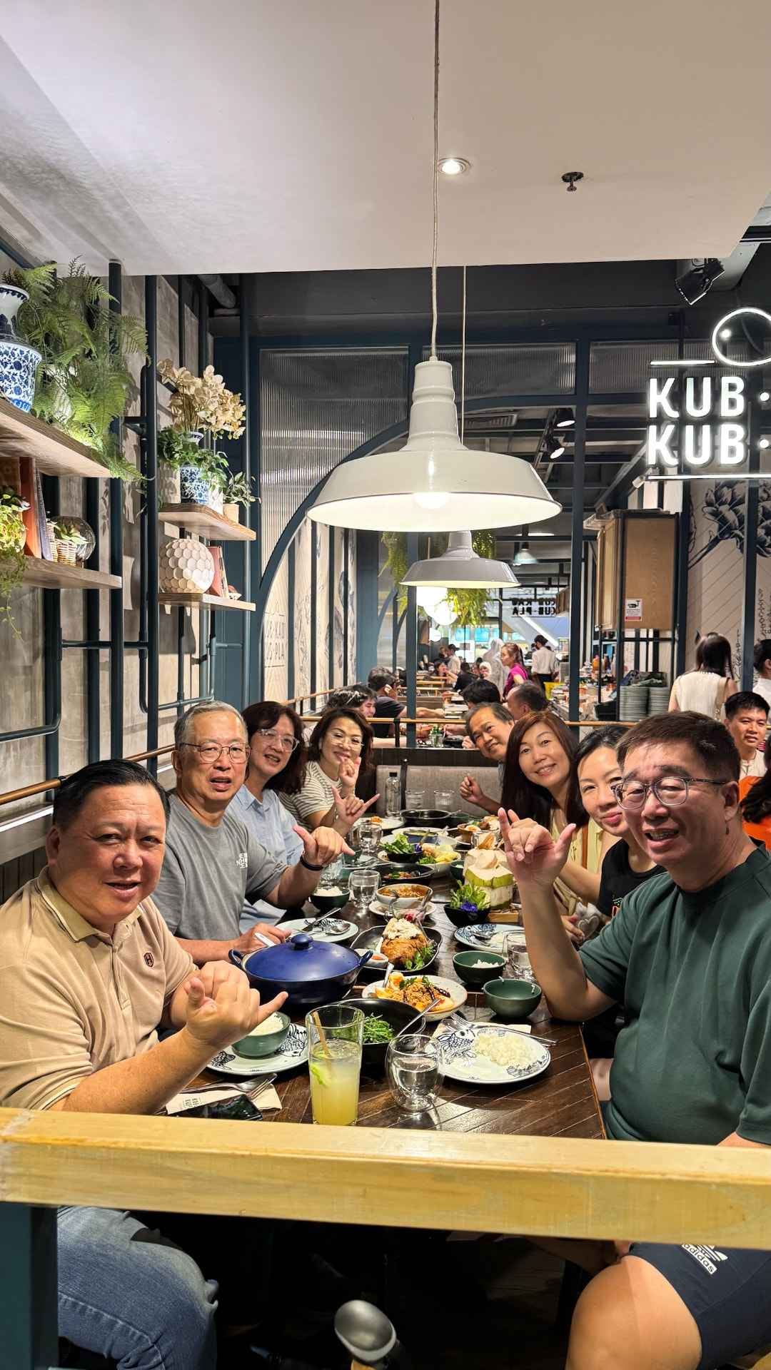 Friends sharing a long table at Kub Kao Kub Pla