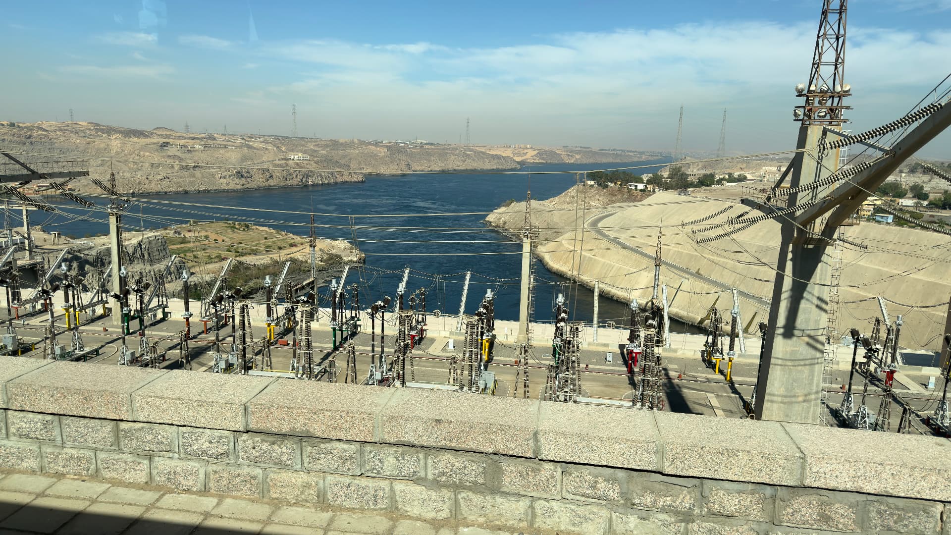 The Aswan dam switchyard with power lines and the narrowed Nile beyond