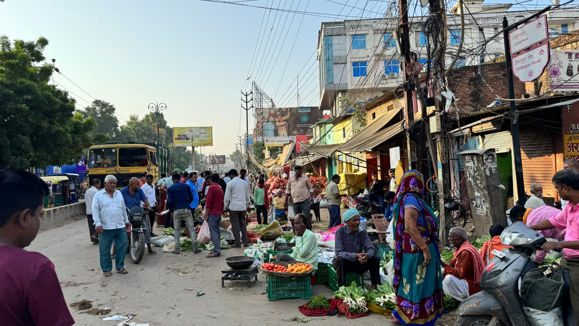 A busy street market lined with vendors and passing shoppers. — Varanasi, Uttar Pradesh, India.