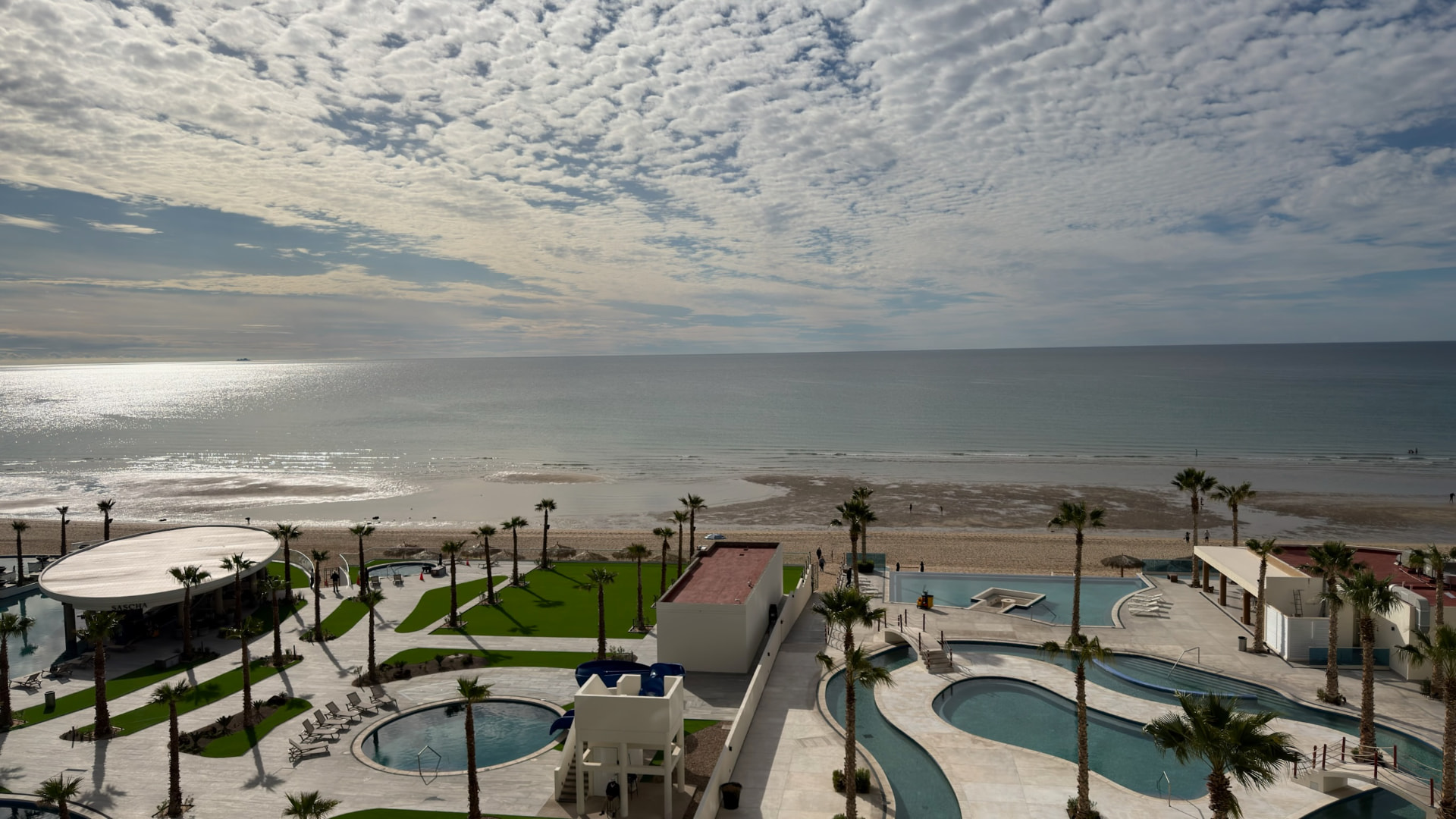 Broad view over pools, palms, beach, and the Sea of Cortez