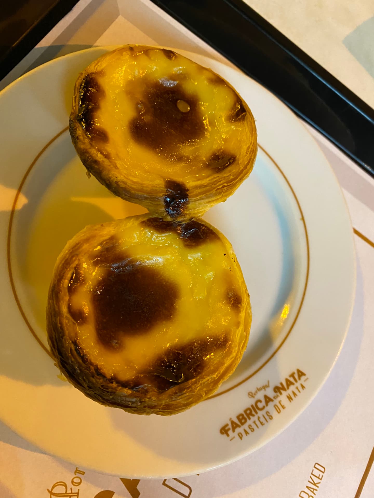 Two pastéis de nata on a plate seen from above