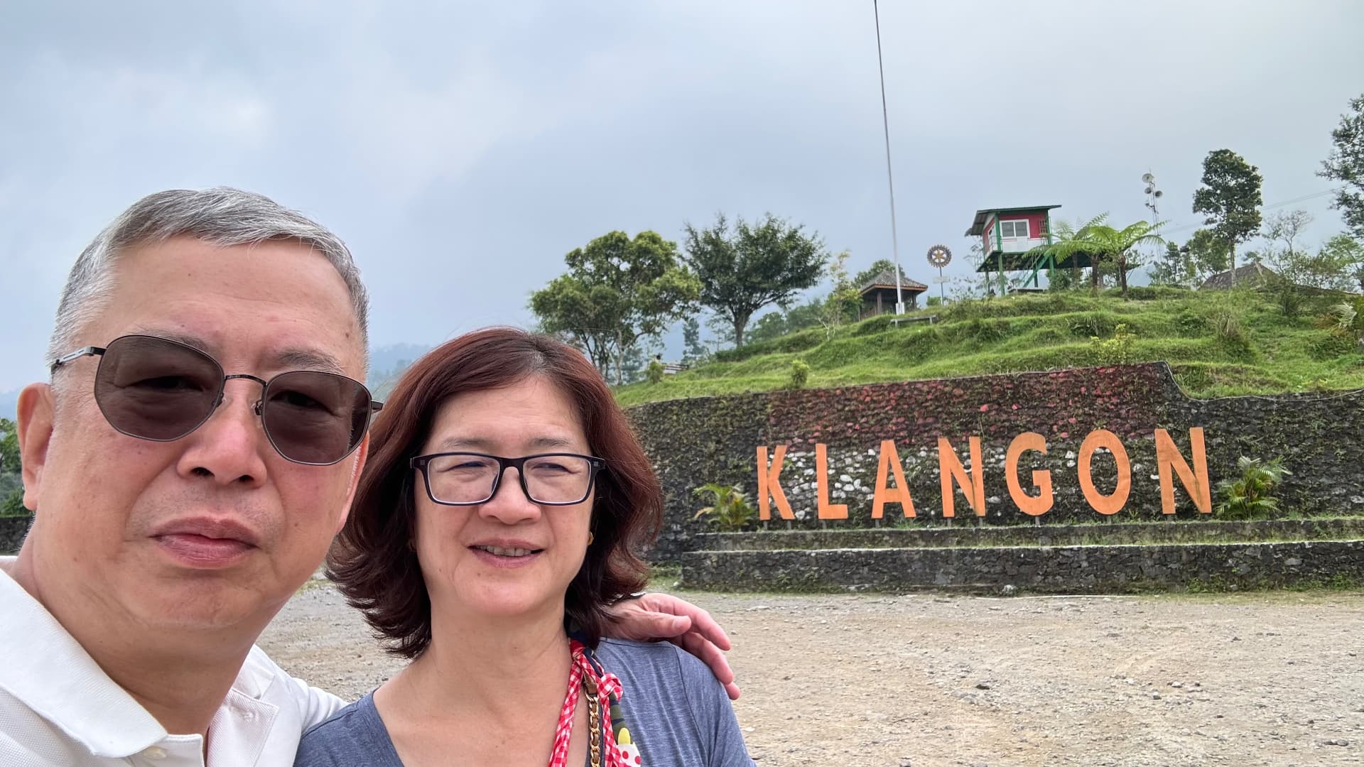 Two travelers posing by the Klangon hillside sign