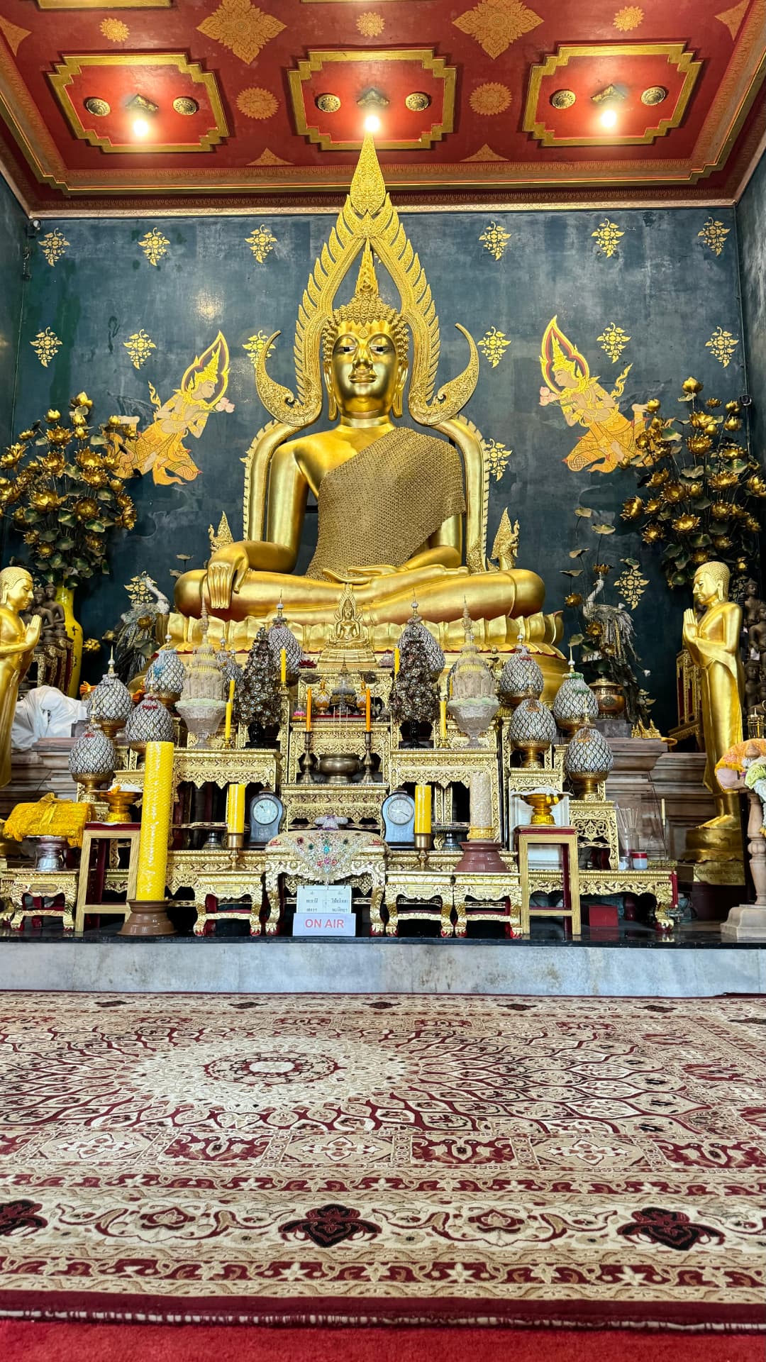 A golden seated Buddha beneath an ornate canopy and decorated ceiling. — Bodh Gaya, Bihar, India.
