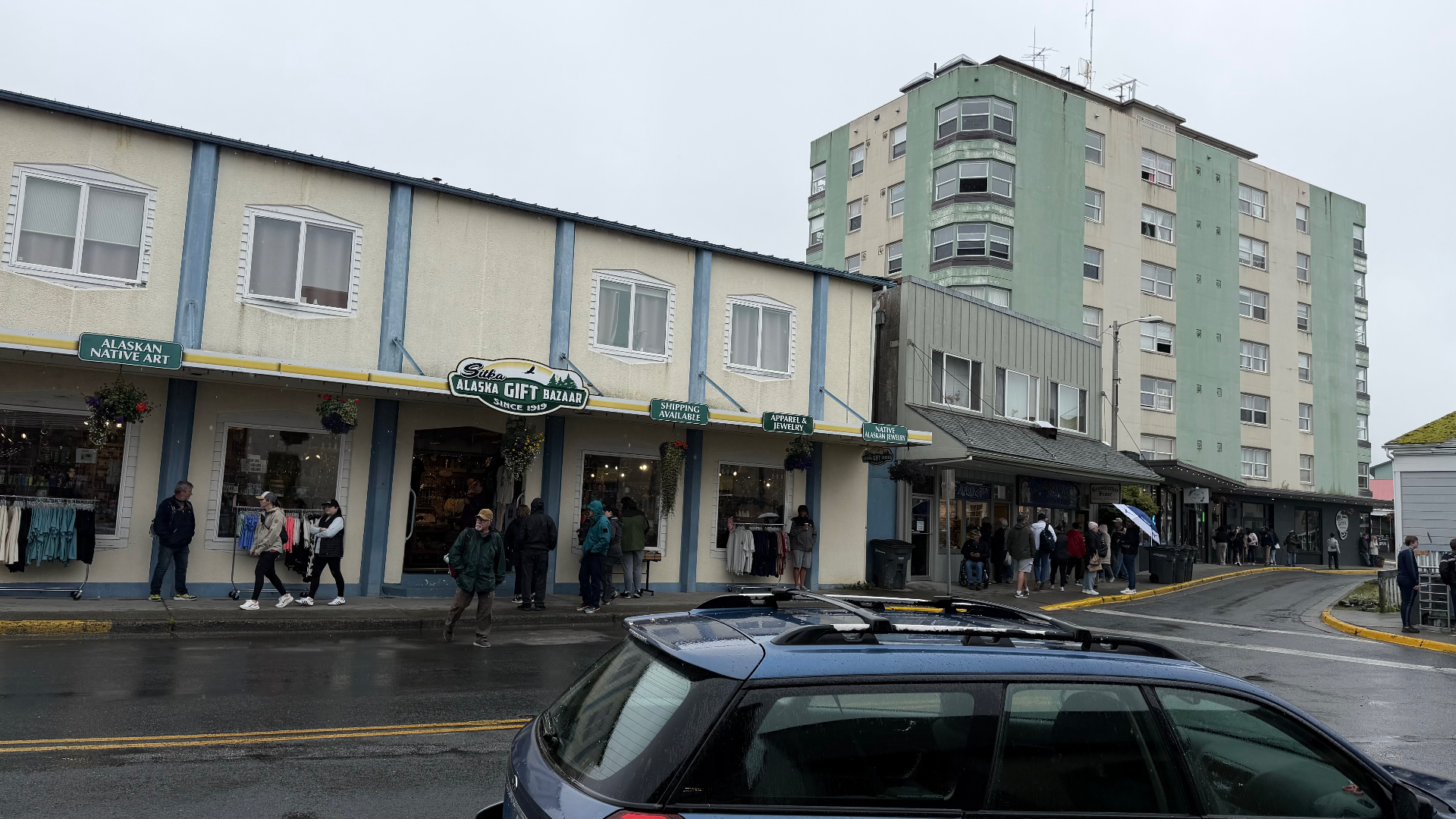 The Sitka Alaska Gift Bazaar storefront with Alaskan Native art signs and shoppers walking along the pavement