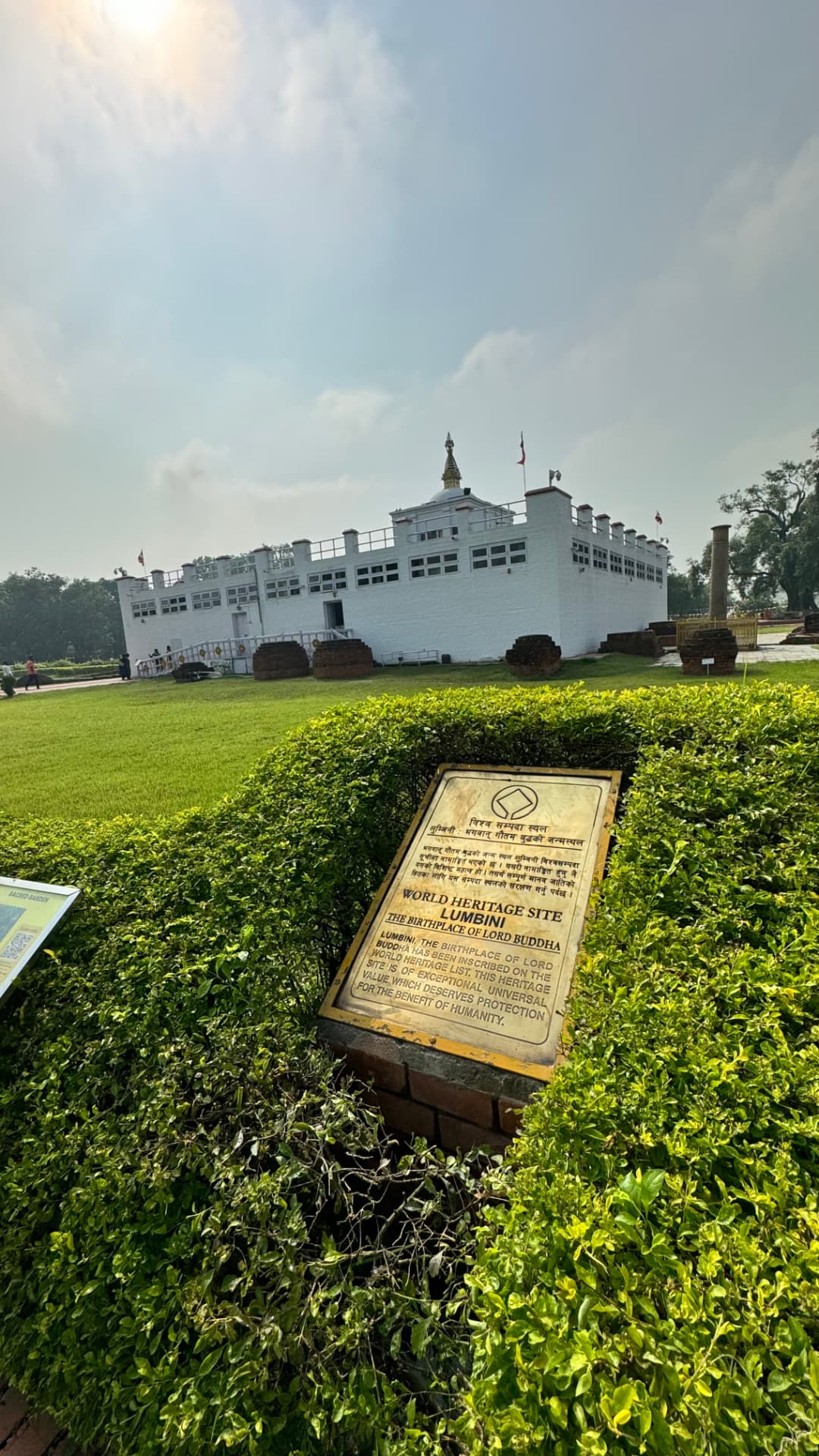 The white Maya Devi Temple rises behind the World Heritage marker. — Lumbini, Nepal.