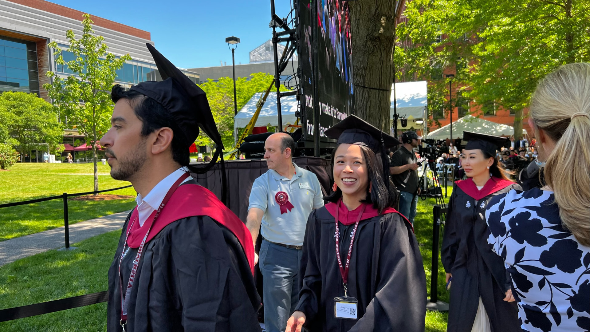 Jocelyn smiling beside the stage as graduates wait for their turn
