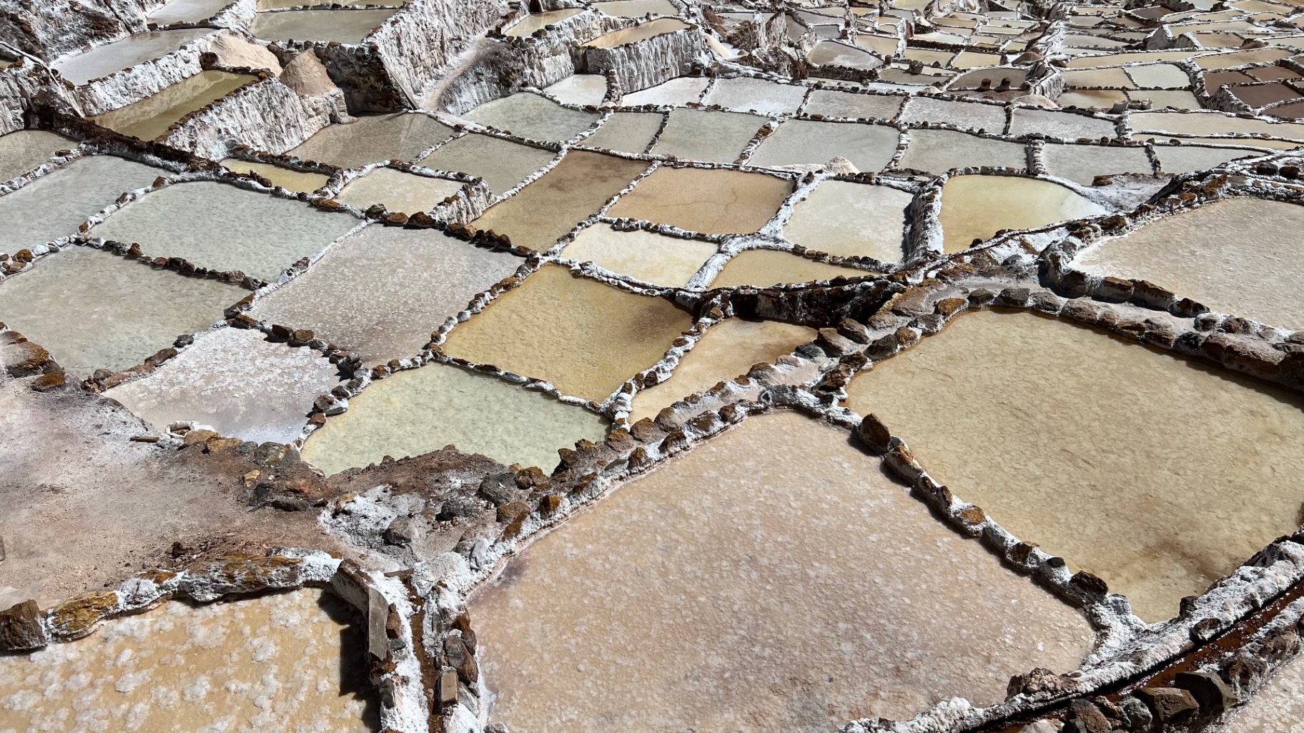 Geometric salt evaporation pools filling a mountain ravine