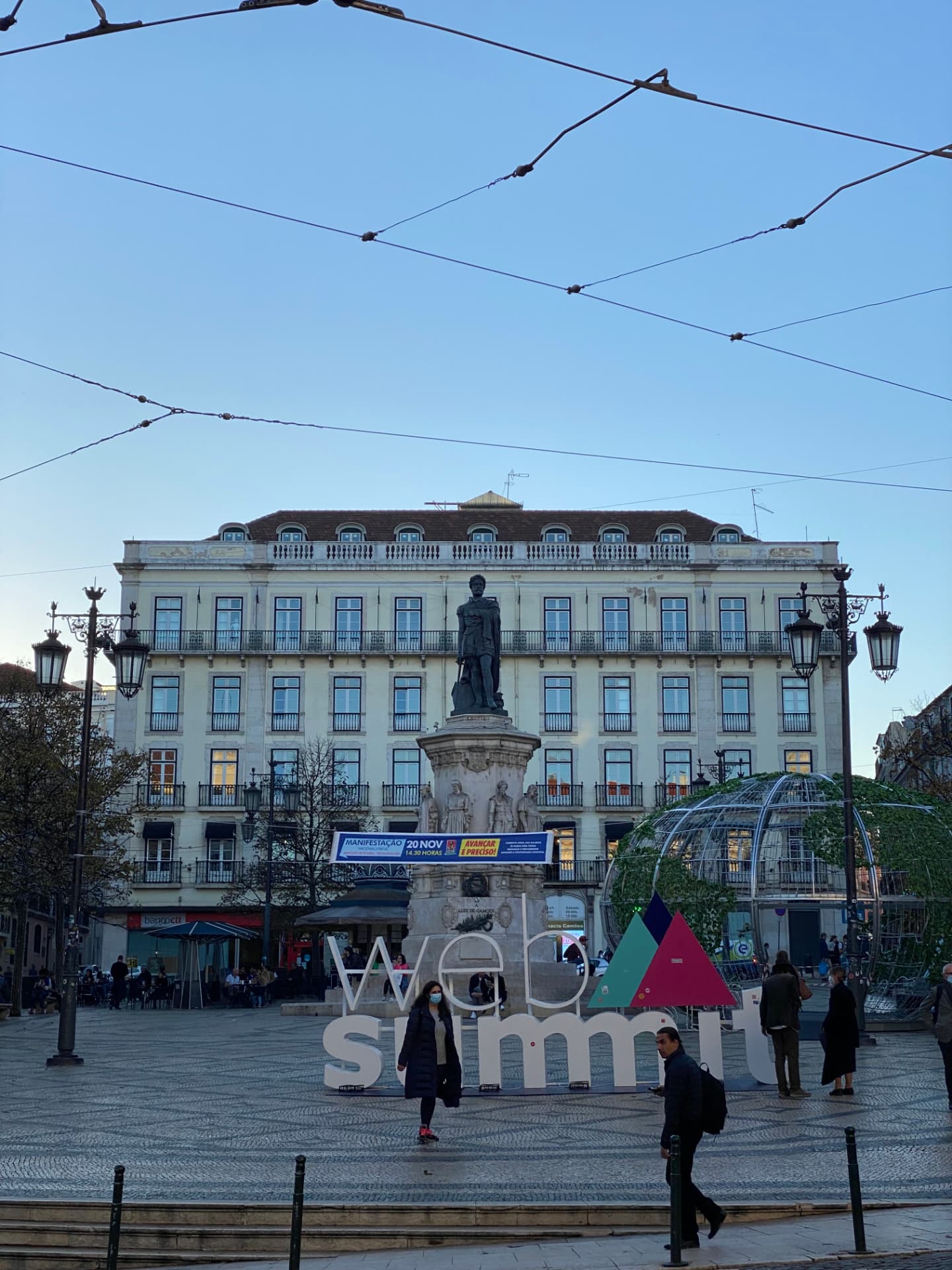 A Lisbon square with a monument and a Web Summit sign
