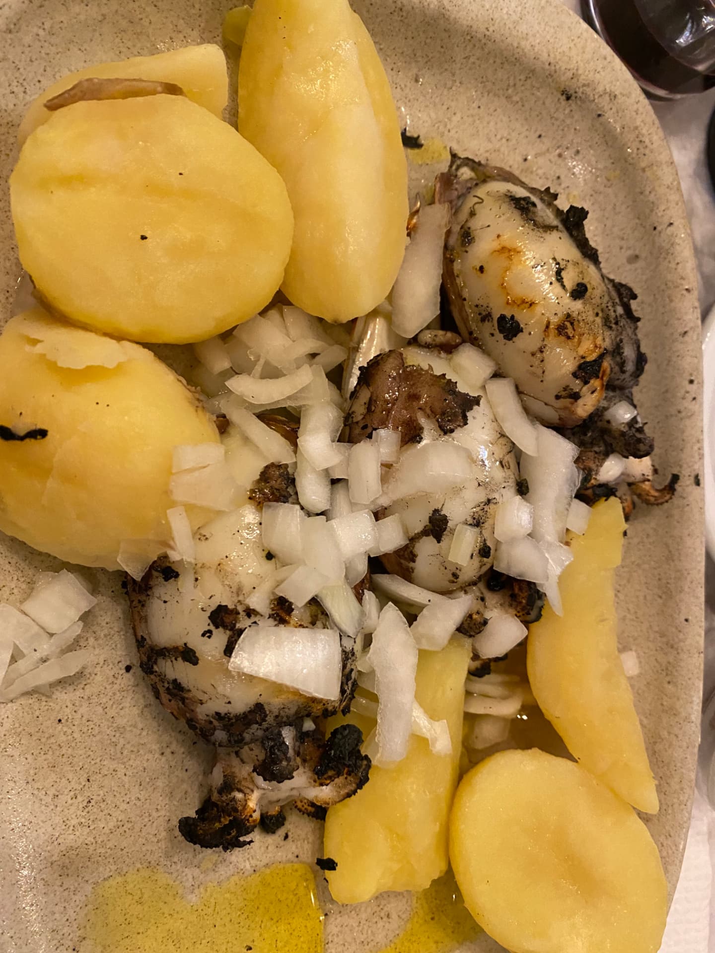 A plate of cooked fish with boiled potatoes and onions
