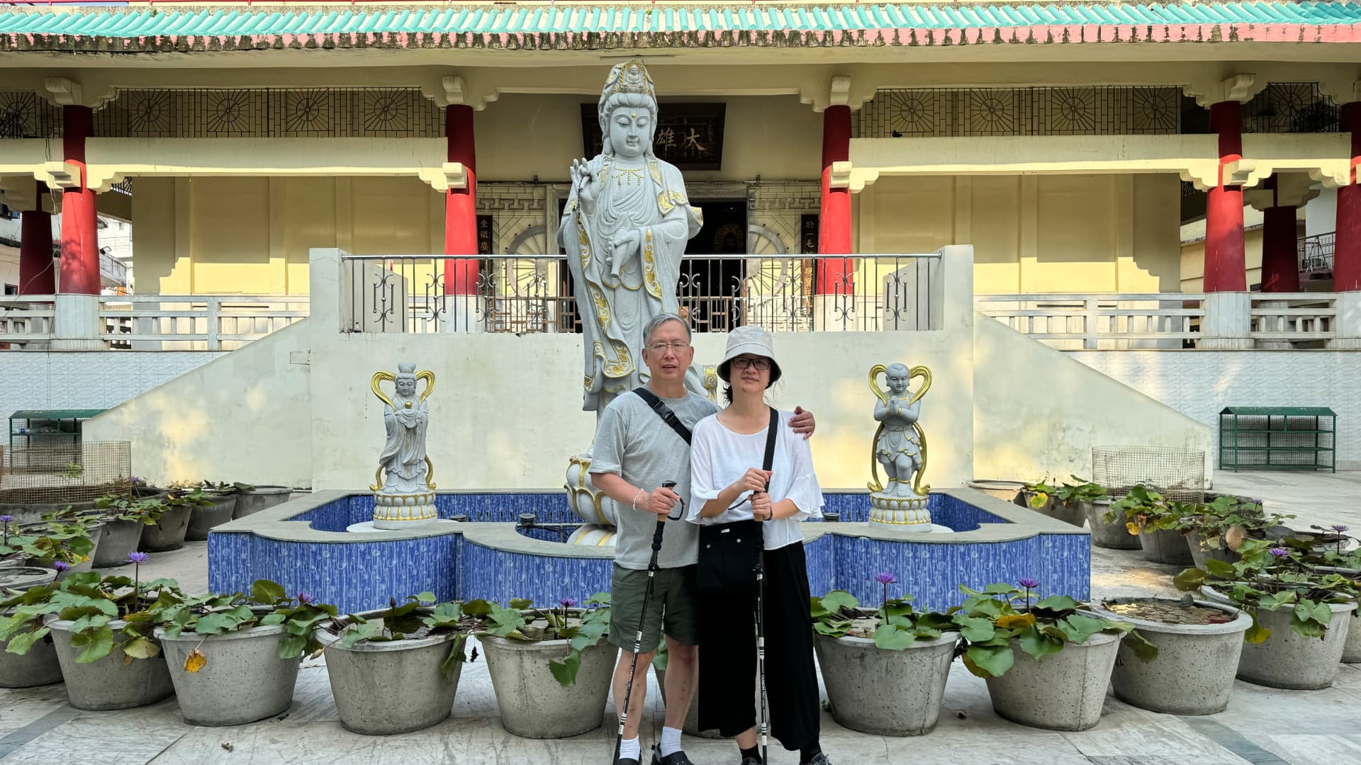 A group portrait in front of a shrine, flower pots and offerings. — Bodh Gaya, Bihar, India.