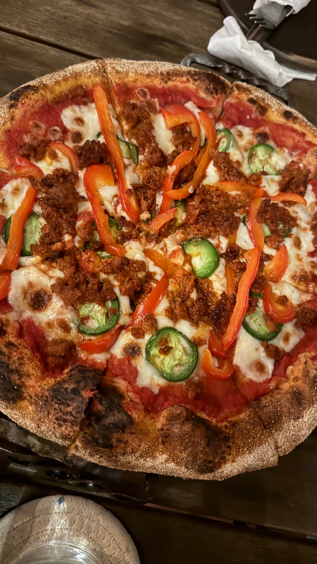 Wood-fired pizza topped with chorizo, peppers, and melted cheese