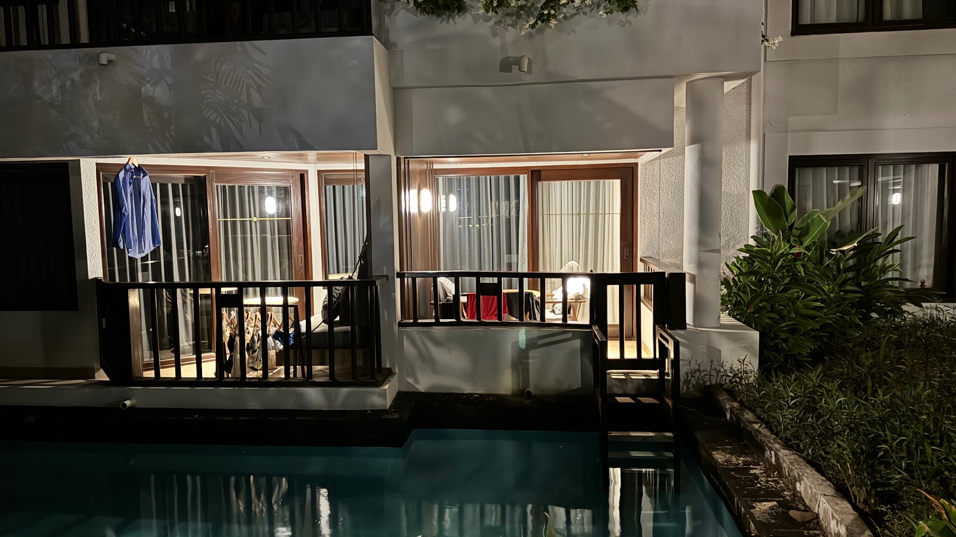 Ground-floor room opening directly onto a lagoon pool at night
