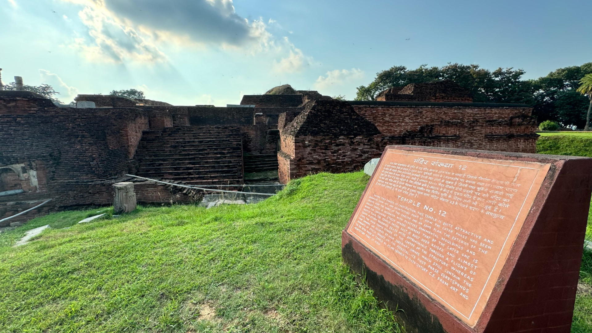 A view across the ruins with an information plaque in the foreground. — Nalanda, Bihar, India · Patna chapter.
