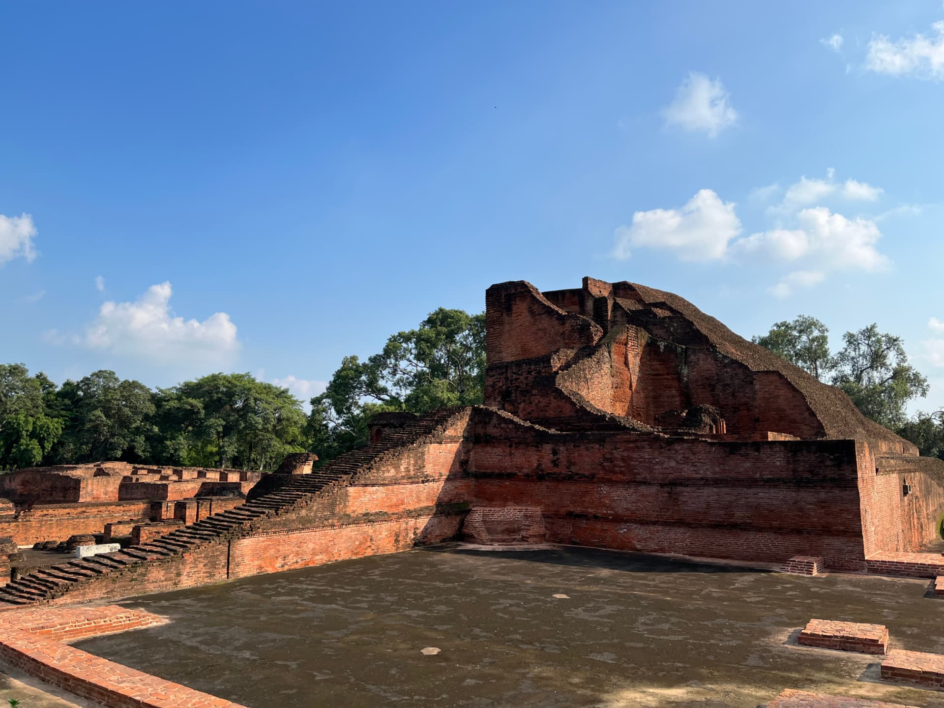 Ancient red-brick structures rise beneath a bright blue sky at Nalanda. — Nalanda, Bihar, India · Patna chapter.