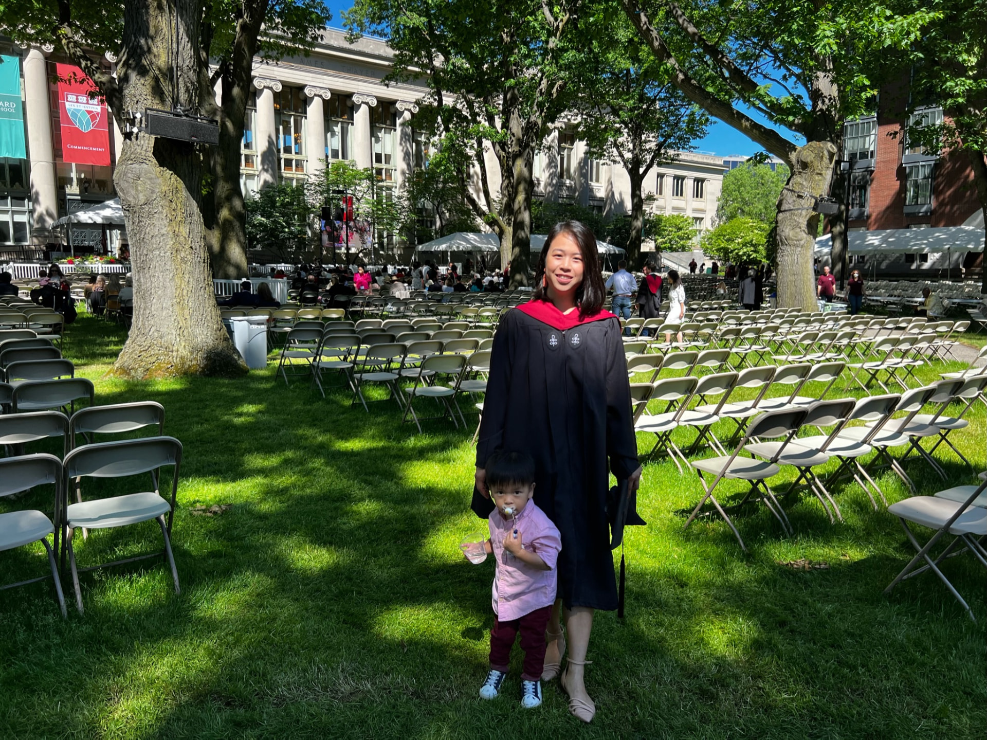 Jocelyn and her son on the lawn among rows of chairs set out for commencement, Harvard Law School behind