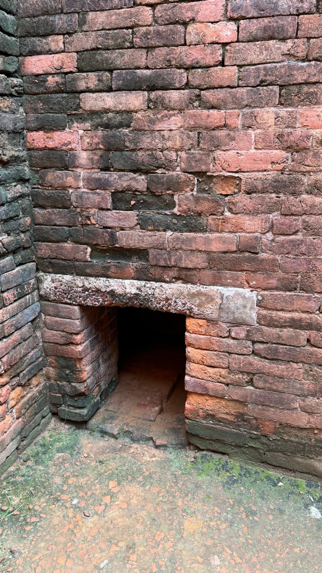 A small opening at the base of a weathered brick wall. — Nalanda, Bihar, India · Patna chapter.