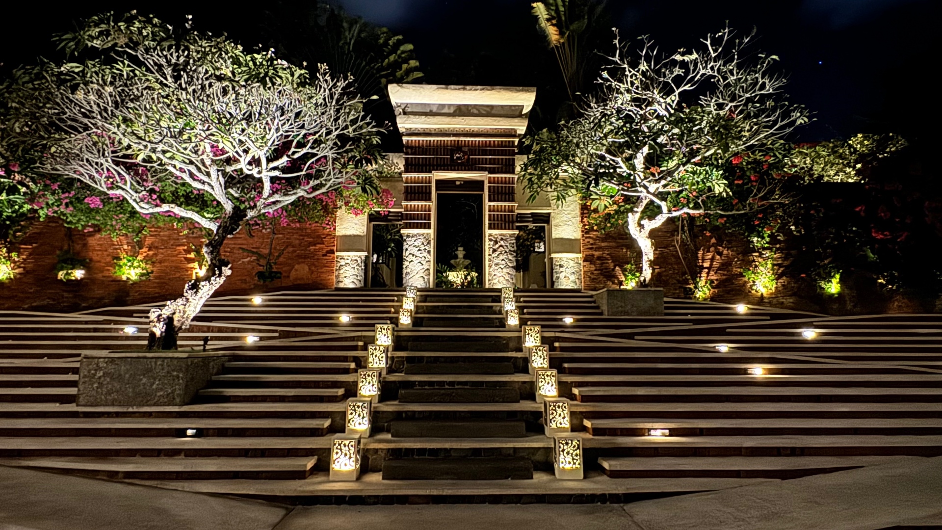 Balinese gate lit by lanterns at the top of broad steps at night