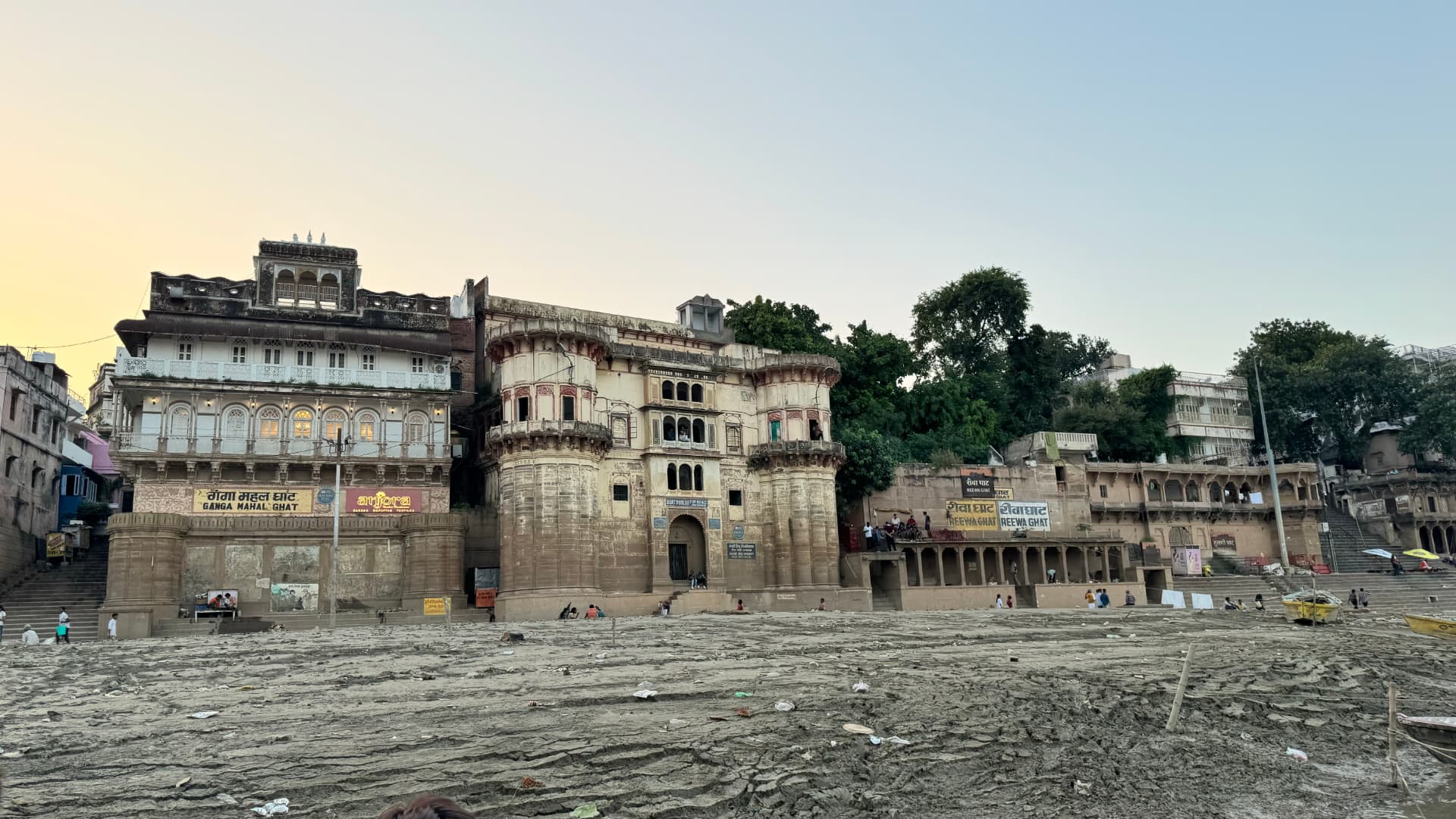 Historic waterfront buildings seen across the Ganges. — Varanasi, Uttar Pradesh, India.