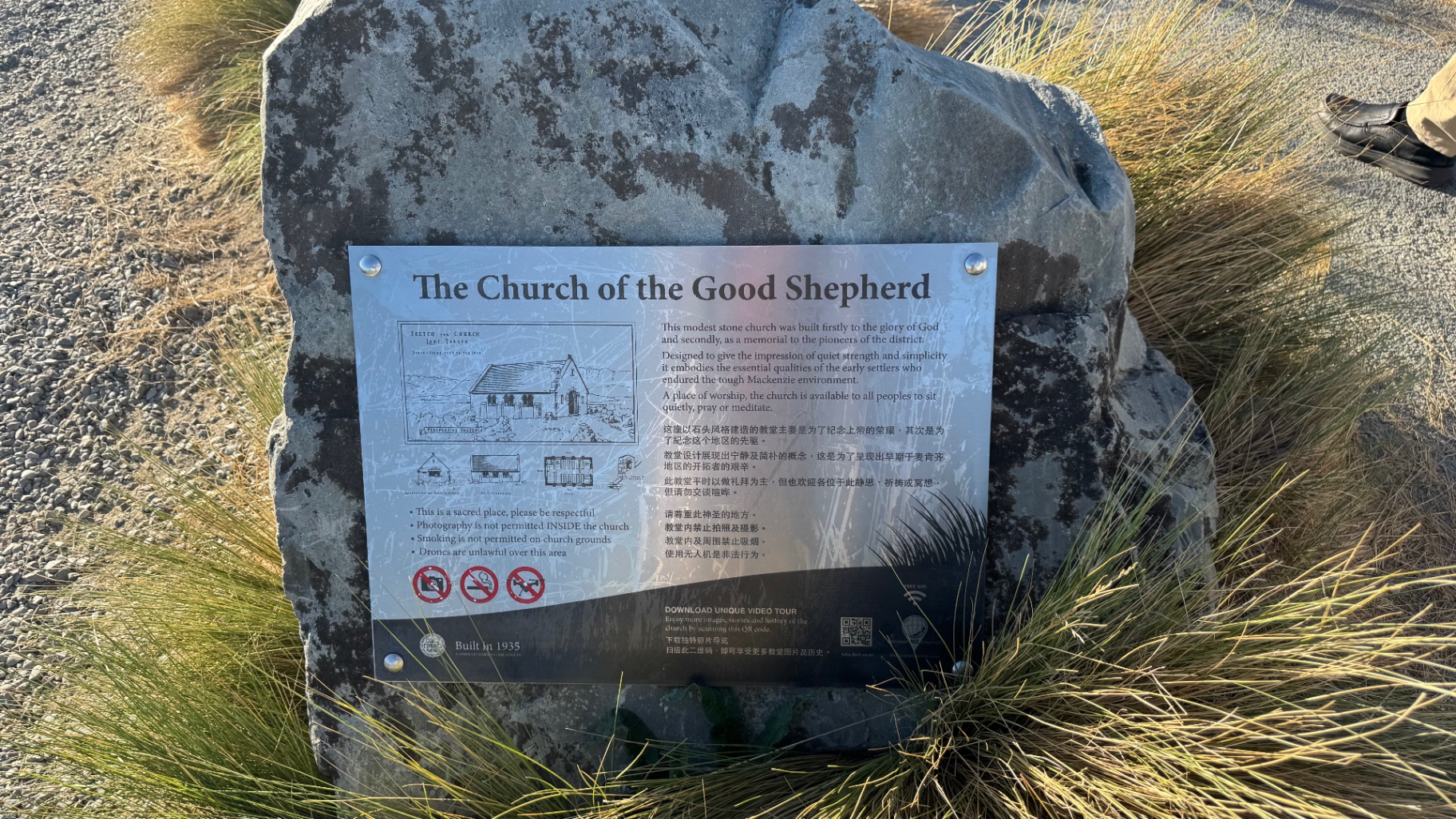 An interpretive plaque mounted on a boulder telling the history of the Church of the Good Shepherd