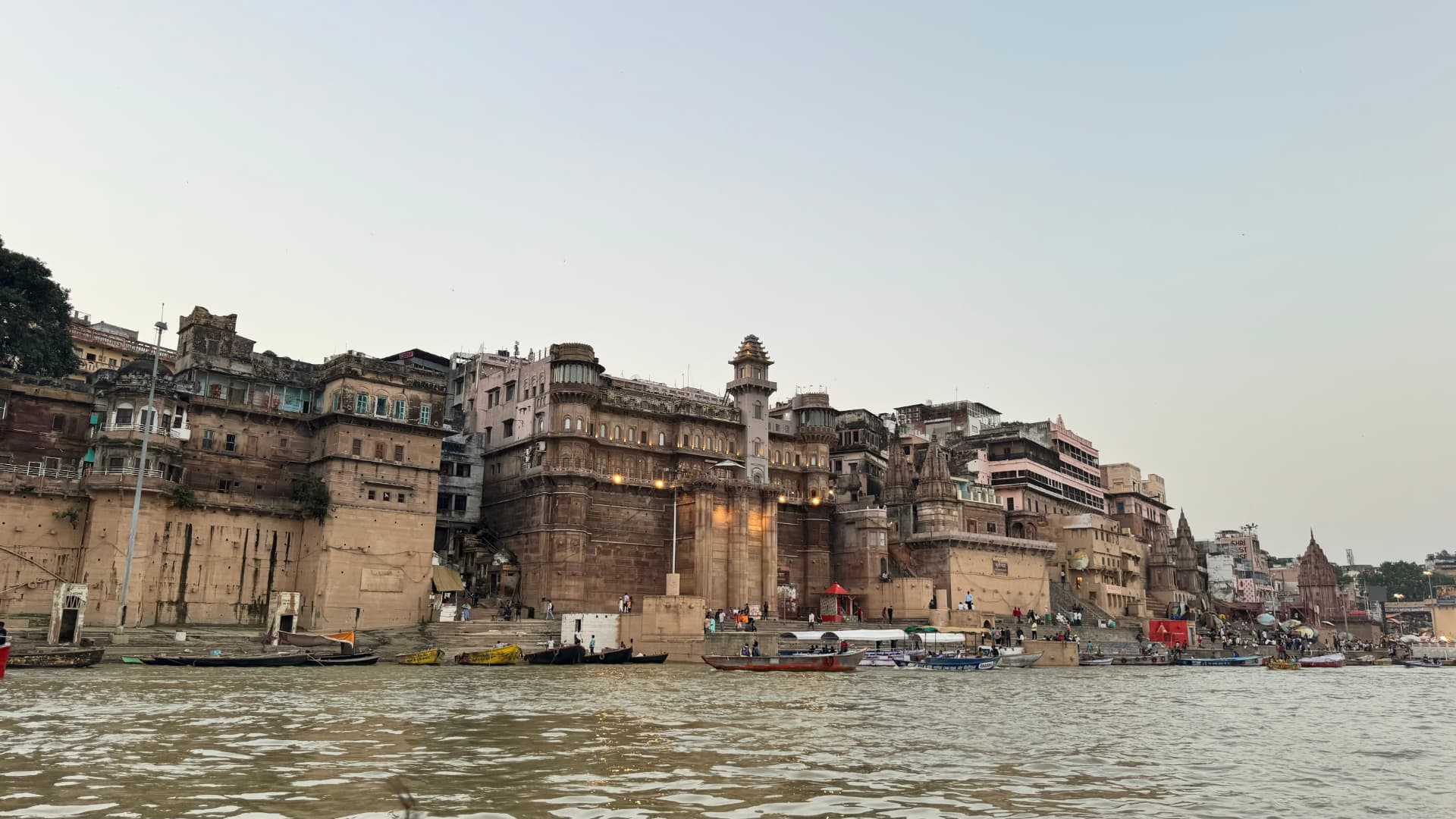 A broad riverside façade reflected in the moving water. — Varanasi, Uttar Pradesh, India.